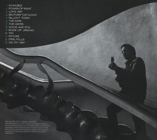 Mann mit Gitarre auf einer Rolltreppe. Schwarz-Weiß-Bild mit modernem Hintergrund.