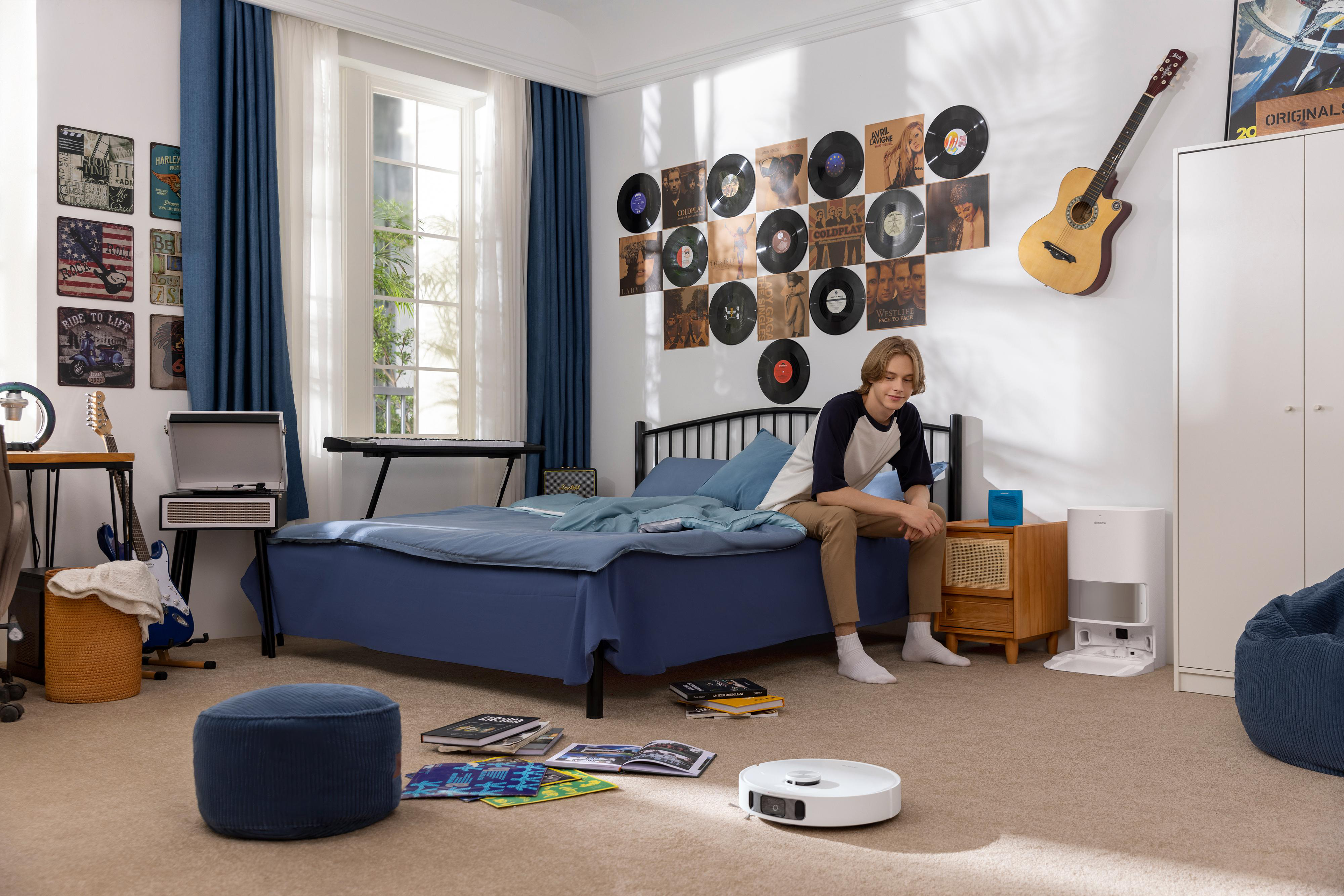 Teenager im Schlafzimmer, Schallplatten, Gitarre, Bett und Reinigungsroboter.