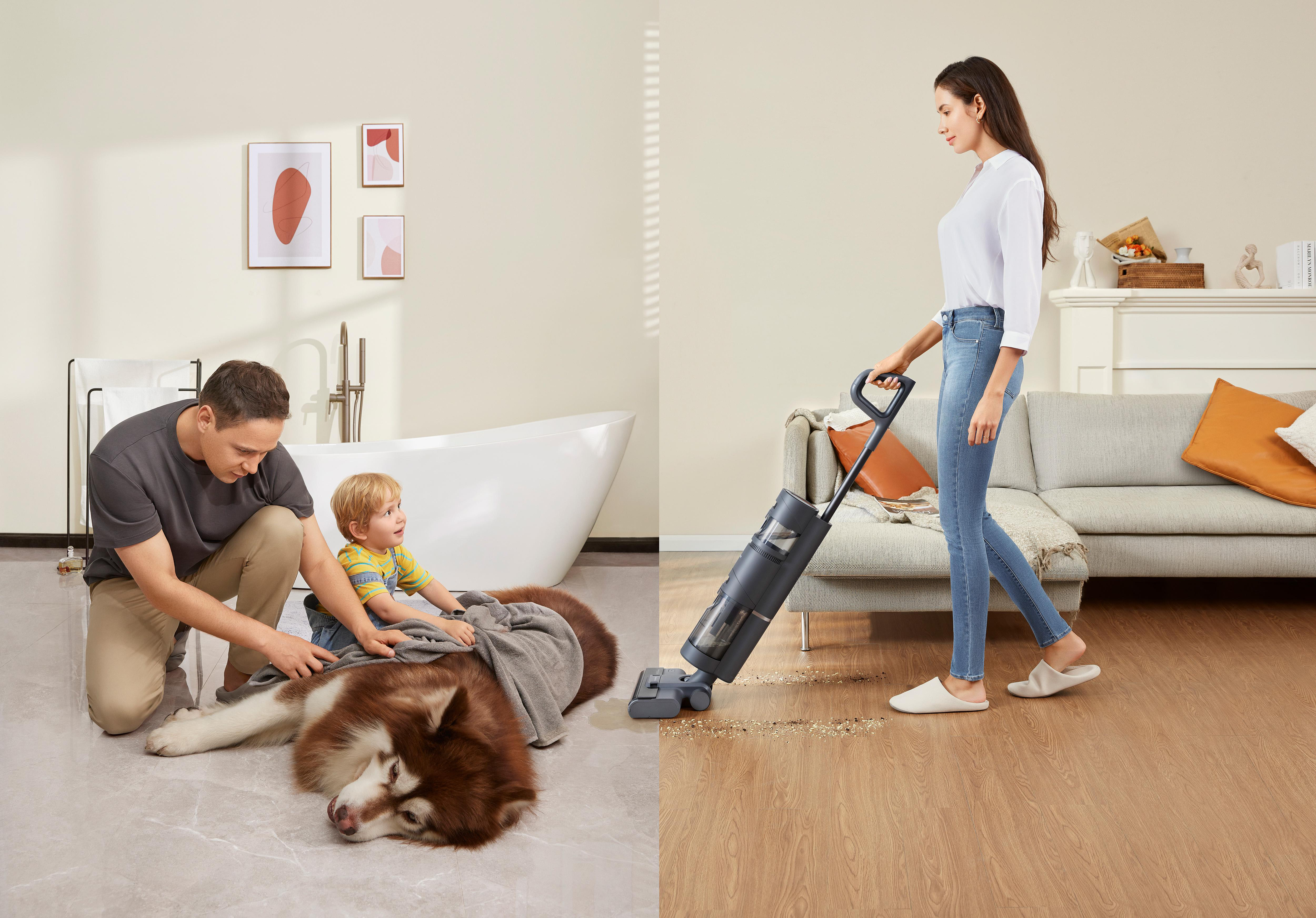 Mann und Kind mit Hund, Frau benutzt Staubsauger.