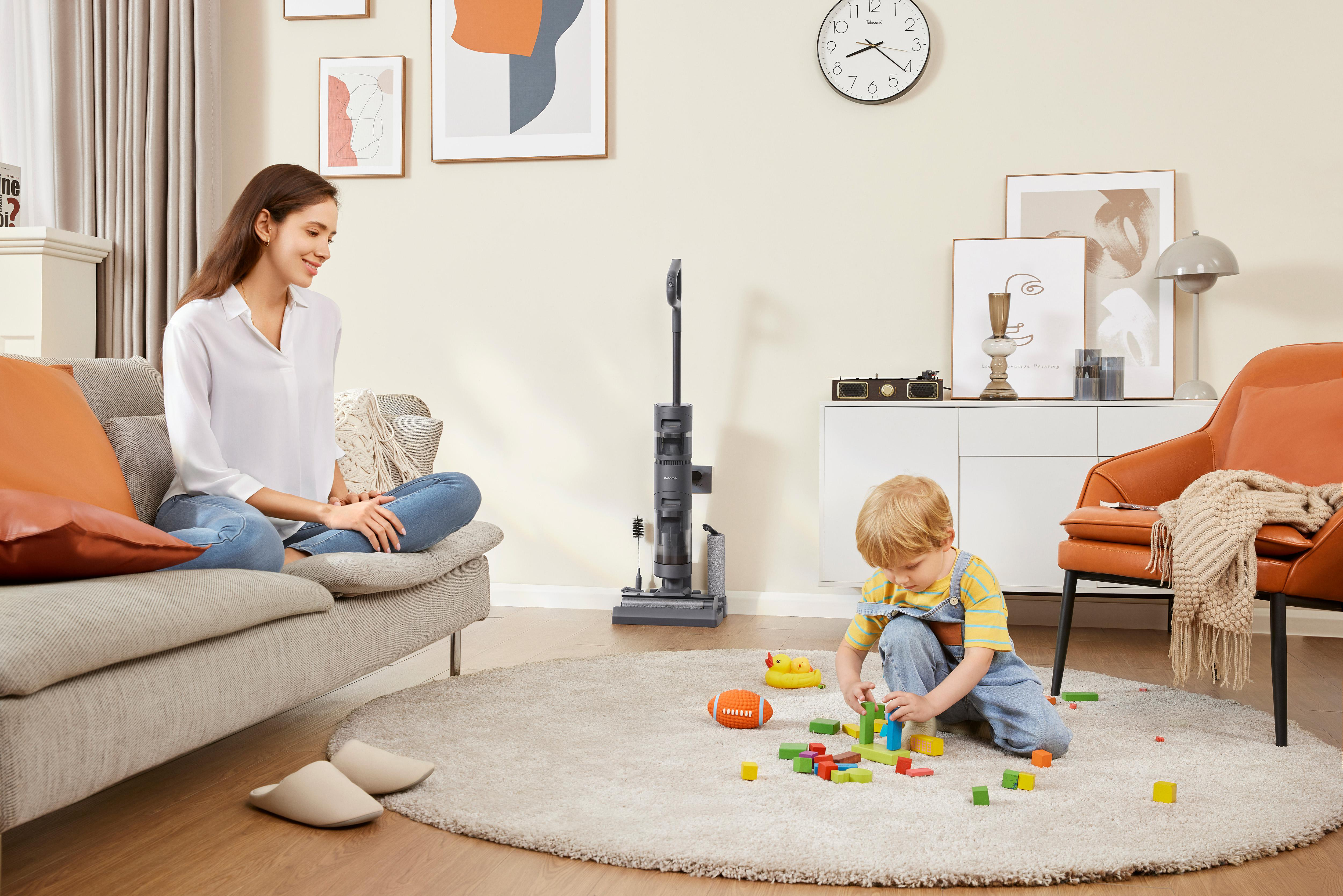 Frau und Kind in einem Wohnzimmer mit Spielzeug.