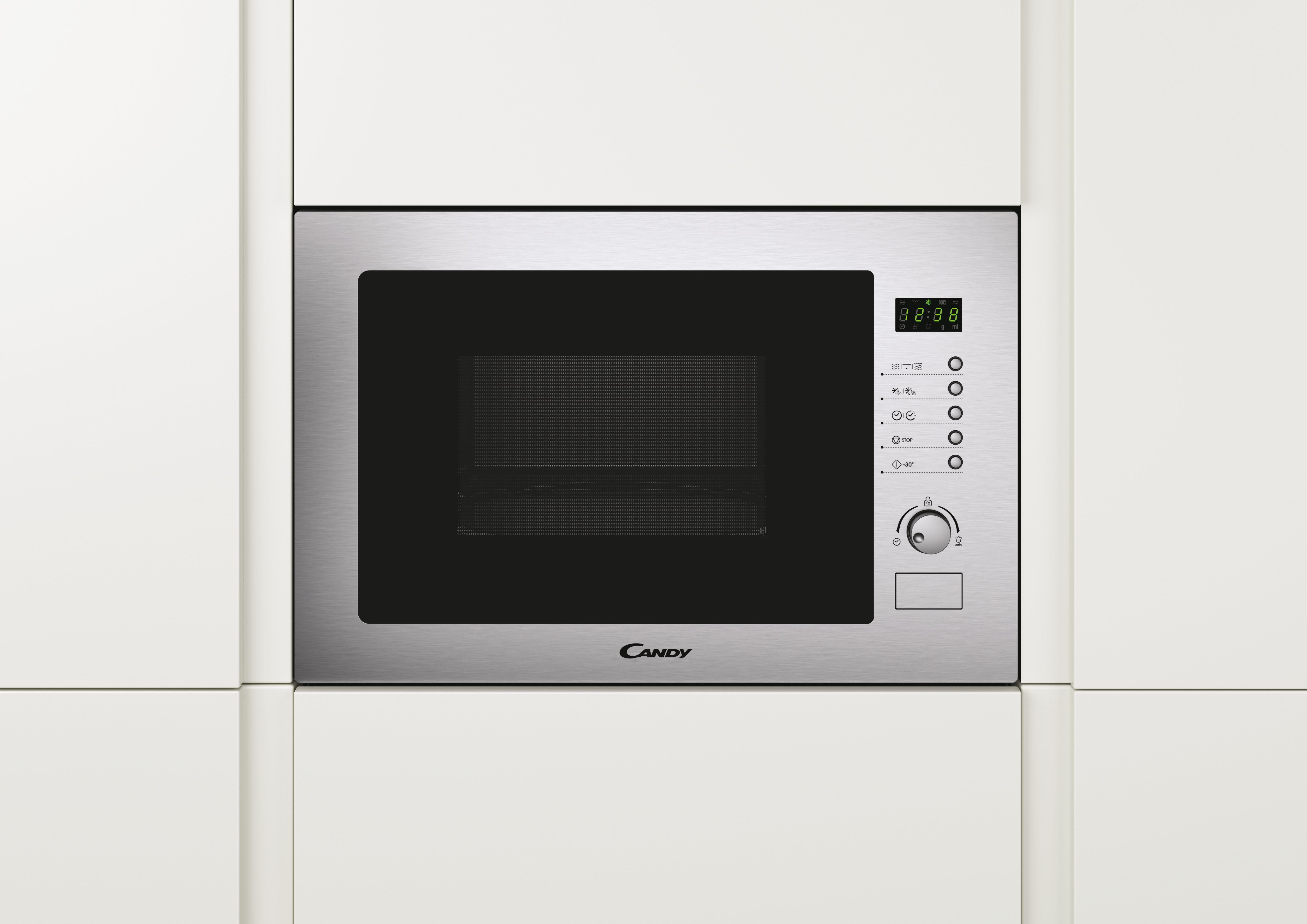 Un horno microondas plateado empotrado en un armario blanco. La pantalla muestra la hora. El logotipo de Candy es visible.