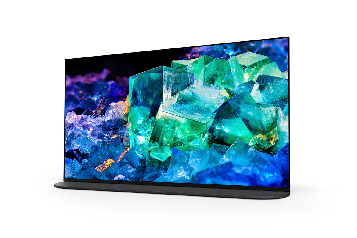 Mavi ve yeşil kristal yapıyı gösteren modern bir TV, siyah bir stand üzerinde.