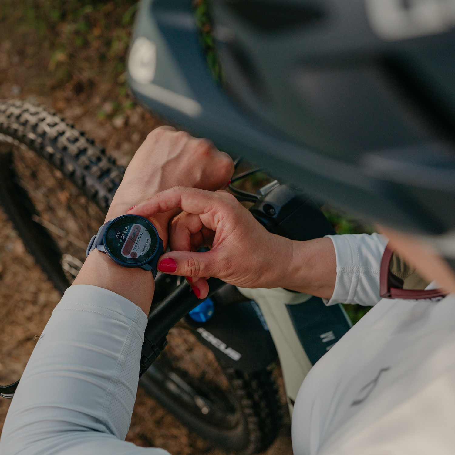 Persona mirando un reloj inteligente en su muñeca mientras anda en bicicleta.