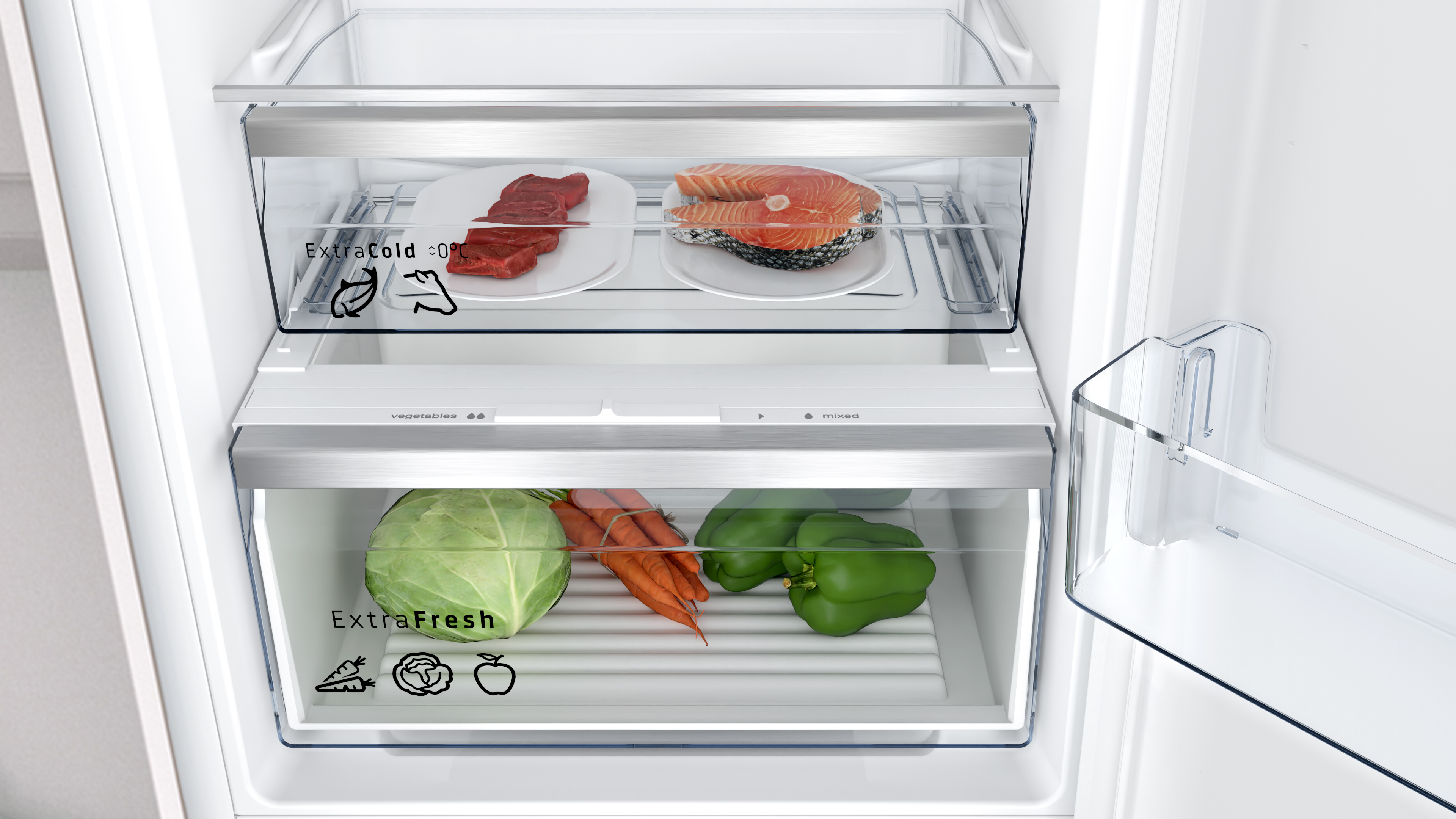 Interior de refrigerador con dos cajones que contienen alimentos. Se ven verduras y carne.