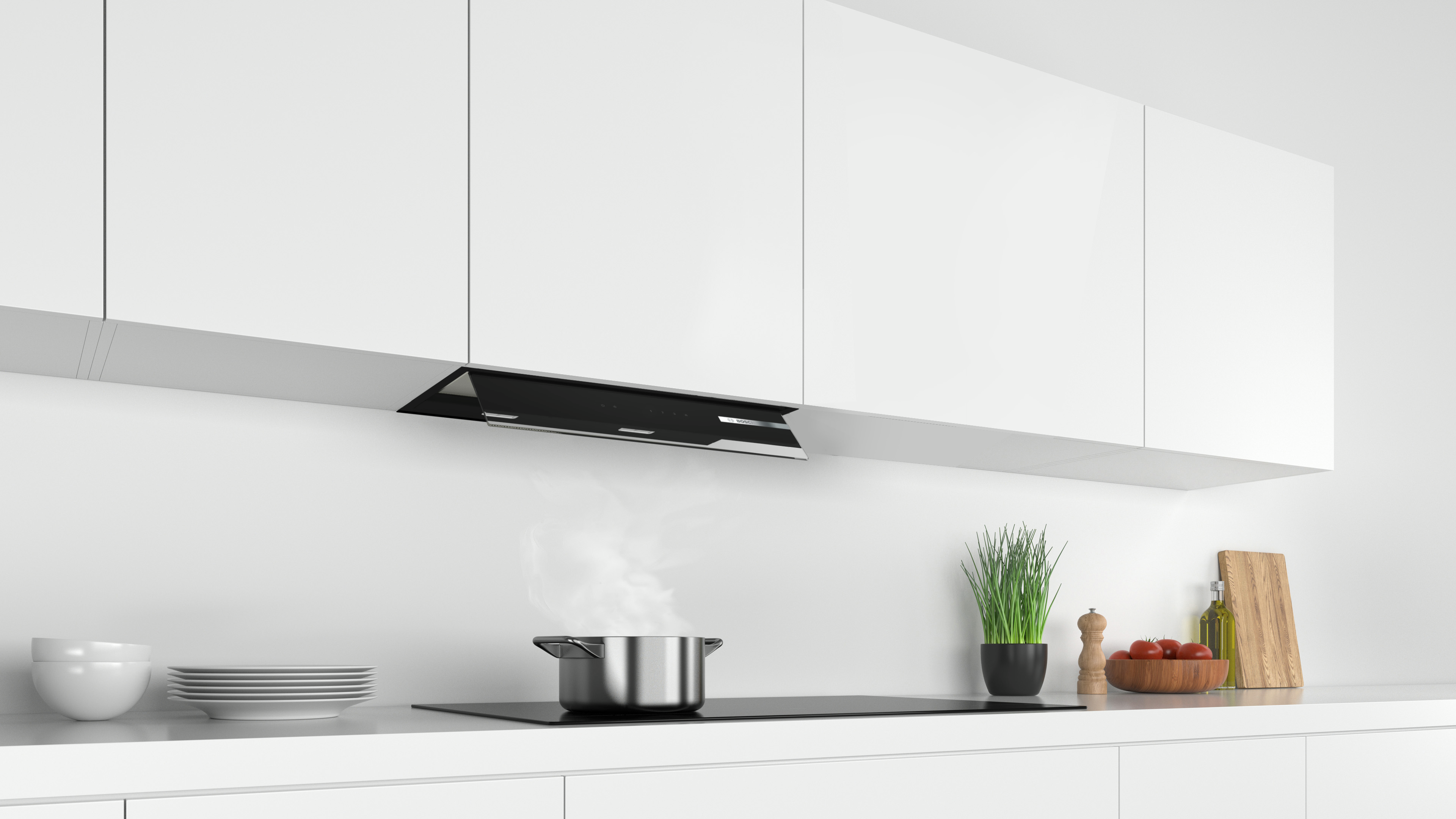 Cocina moderna con gabinetes blancos, vitrocerámica con olla y campana extractora.