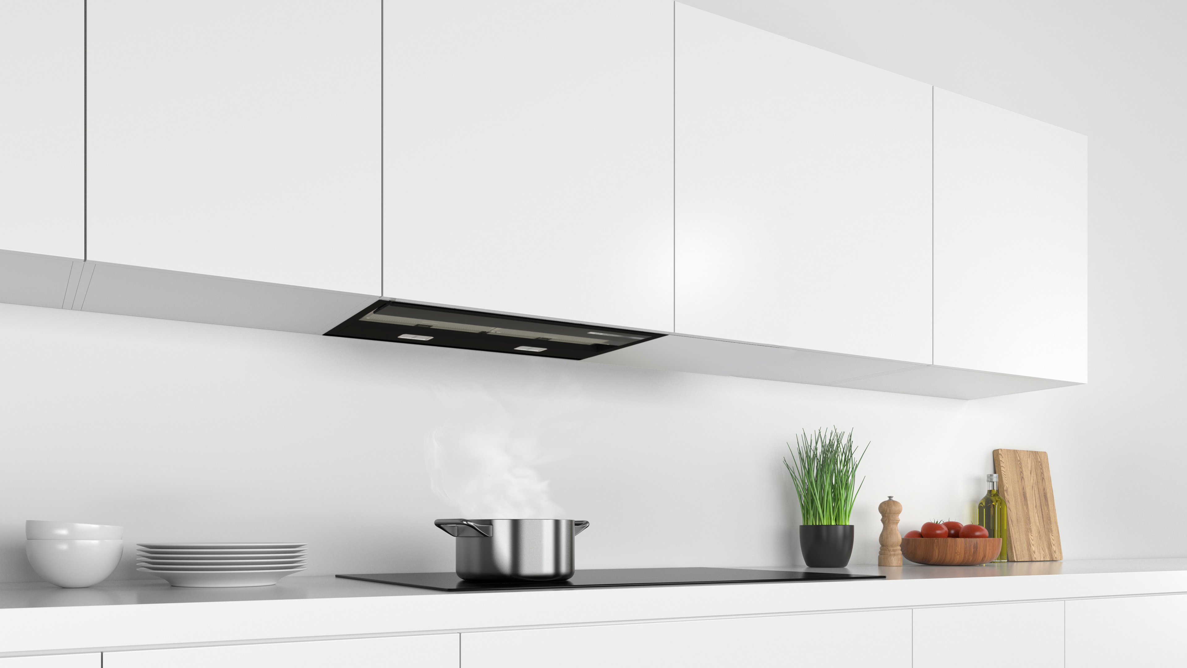 Una cocina blanca con una estufa negra, una olla con vapor y gabinetes blancos.