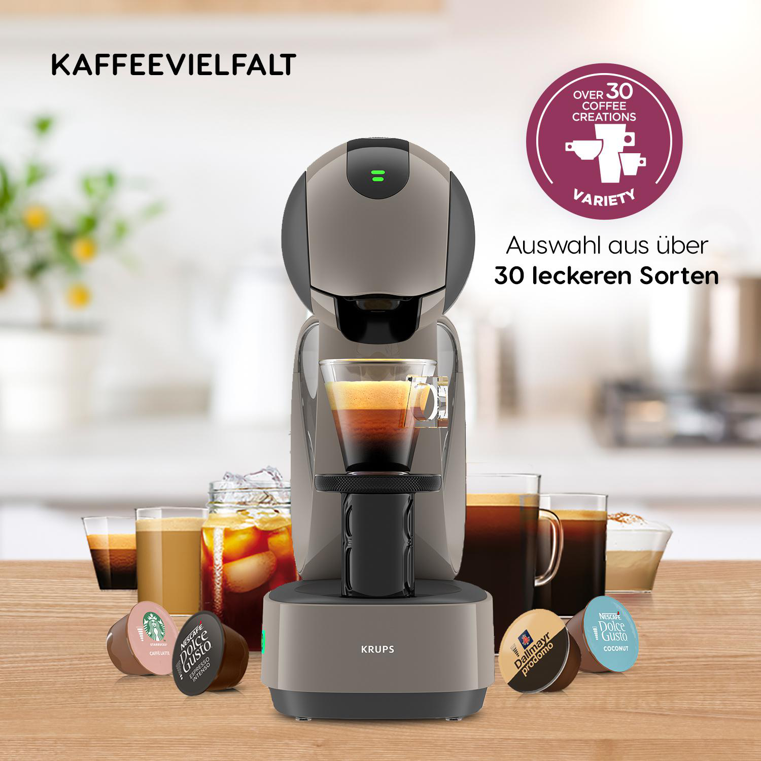 Eine Krups Kaffeemaschine mit Kapseln und verschiedenen Kaffeegetränken drumherum.