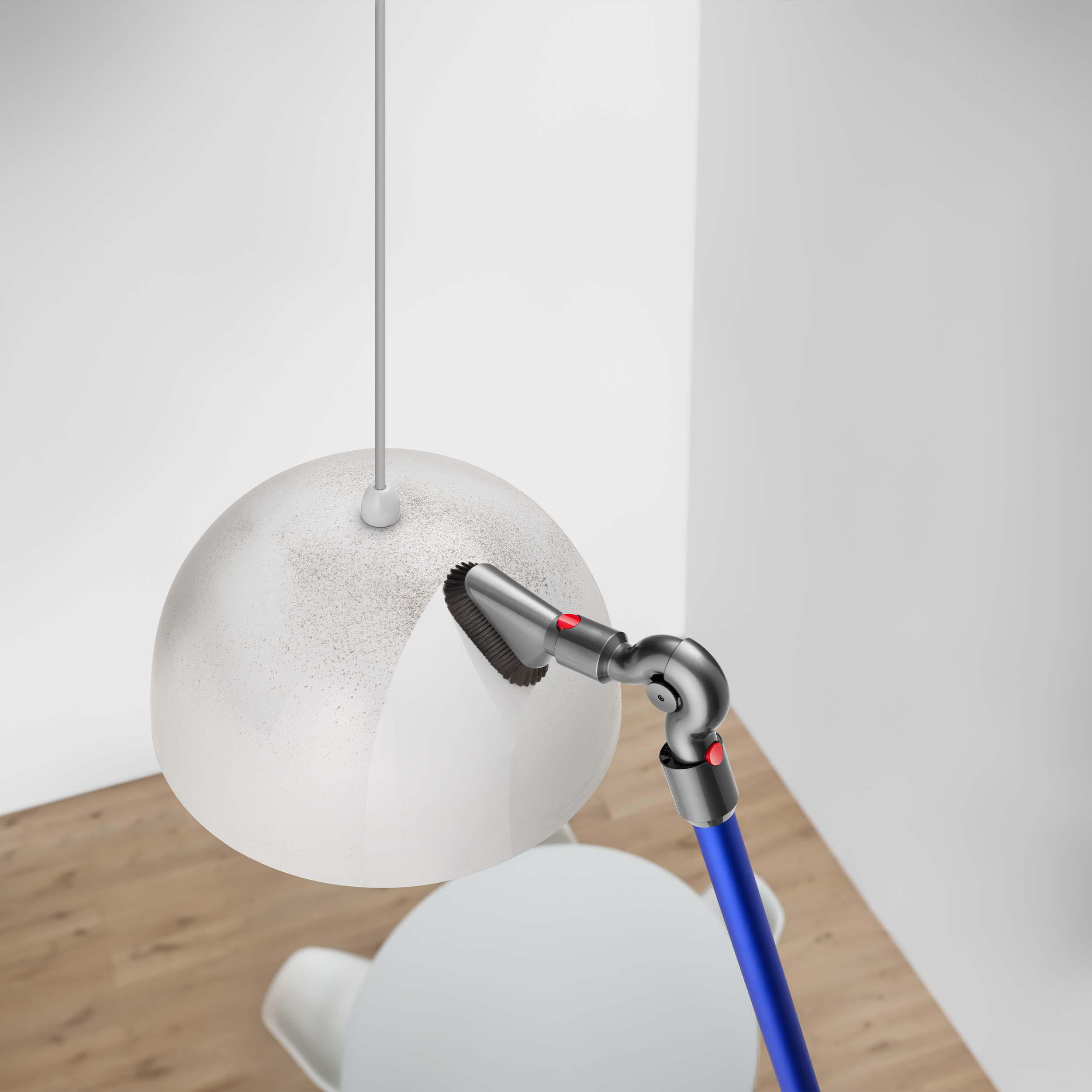 Eine Person saugt eine Leuchte mit einem Dyson ab. Weiße Wand, Holzboden.