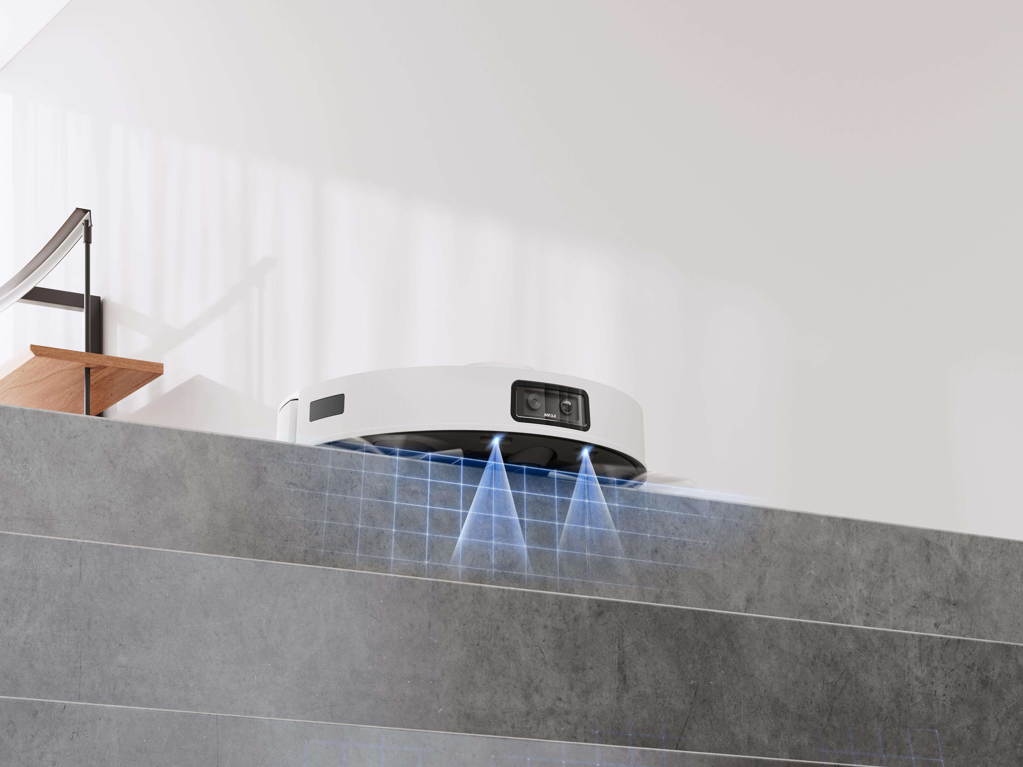 Ein weißer Roboter-Staubsauger auf einem grauen Absatz, der blaues Licht aussendet.