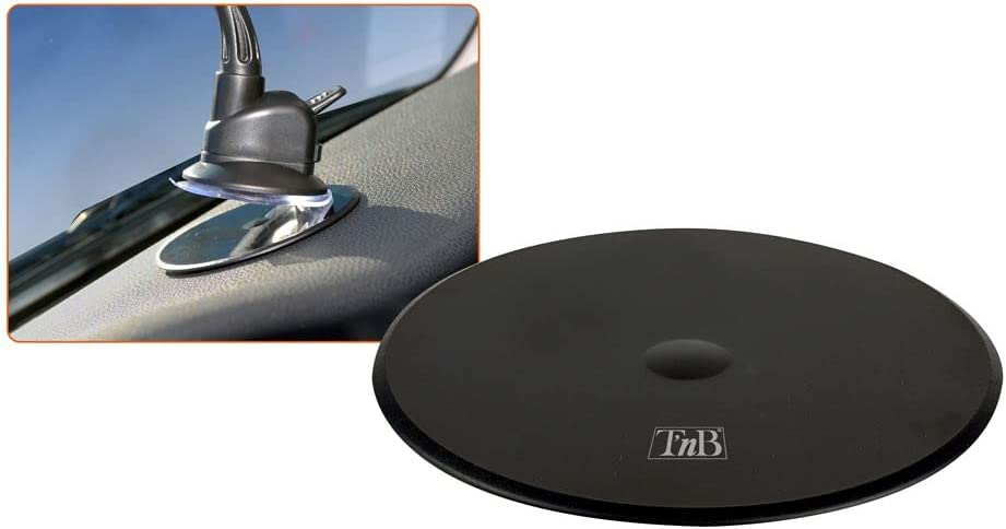 Un tableau de bord de voiture avec un support de téléphone et un objet rond noir dessus. Le support est fixé.