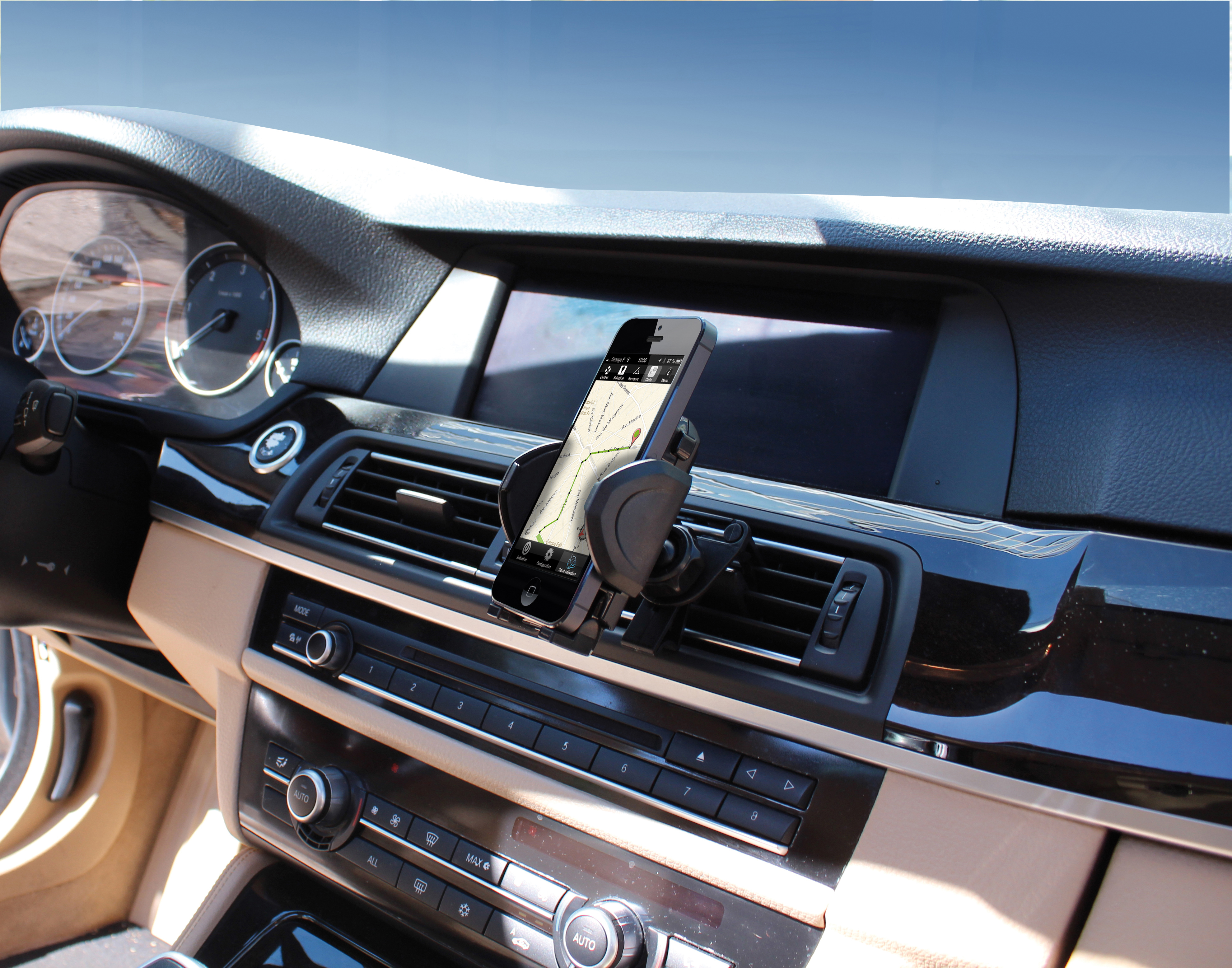 Un téléphone affiche une carte dans une voiture. Il est tenu par un support noir fixé au tableau de bord.
