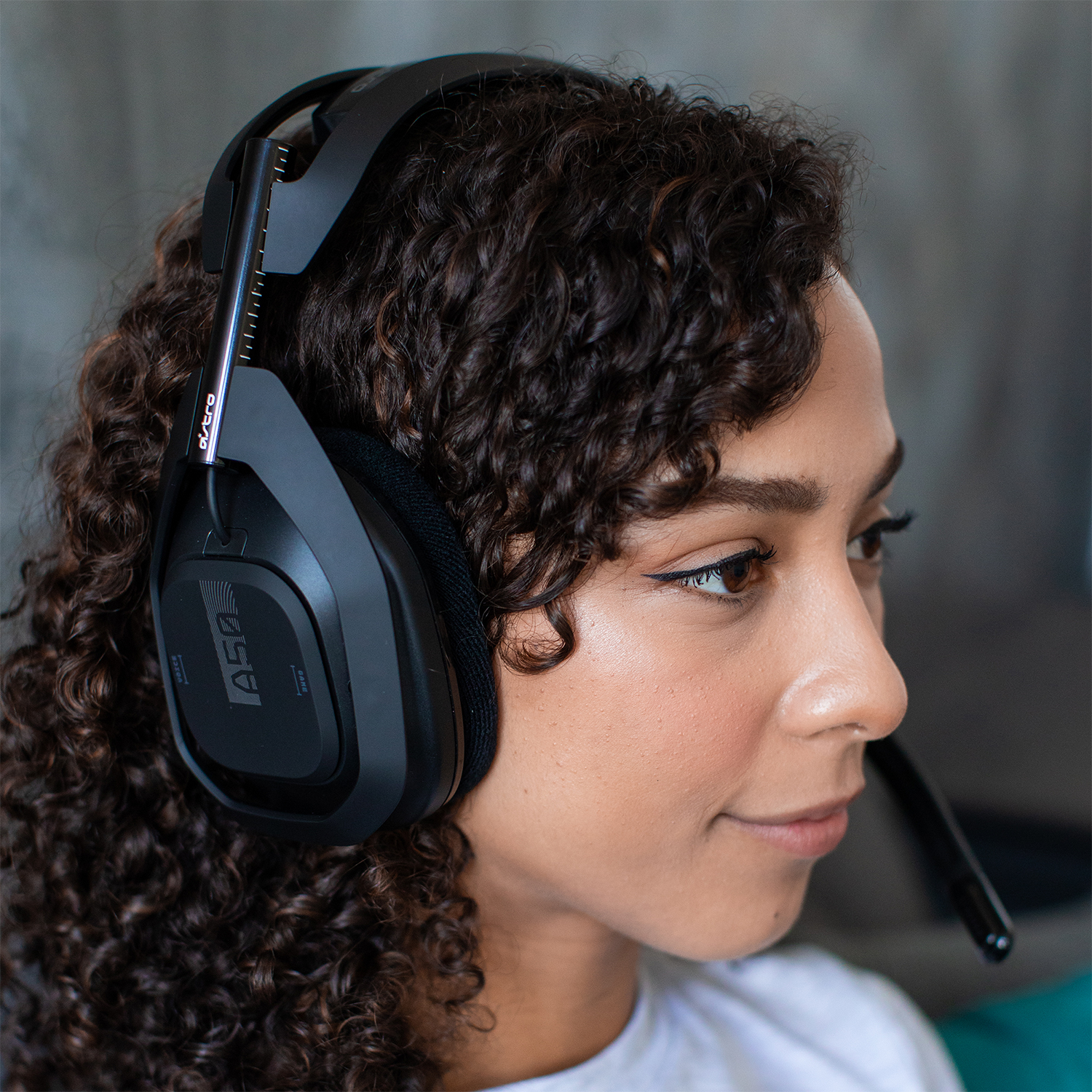 Femme portant un casque de jeu noir, regardant vers la droite.