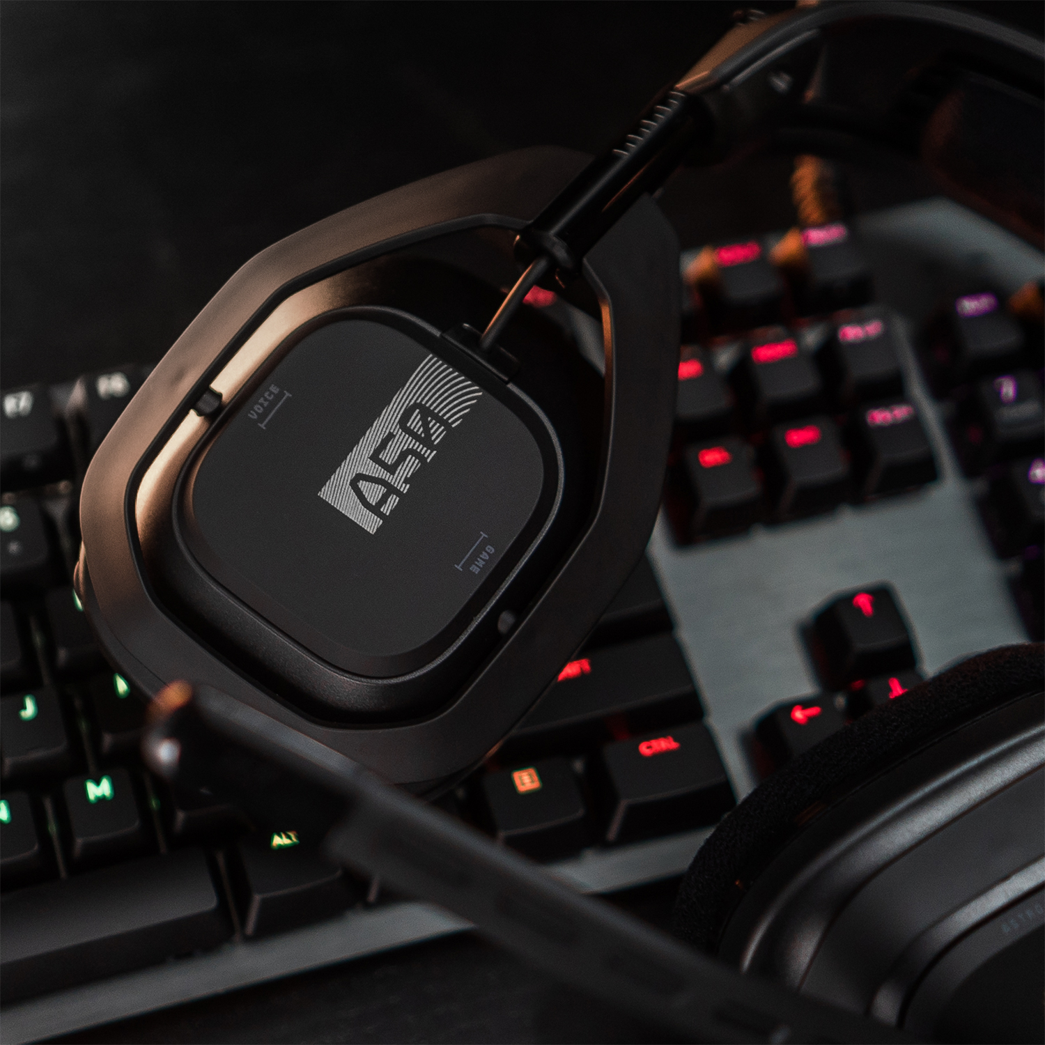 Casque de jeu noir sur un clavier. Le logo du casque et les touches du clavier sont visibles.