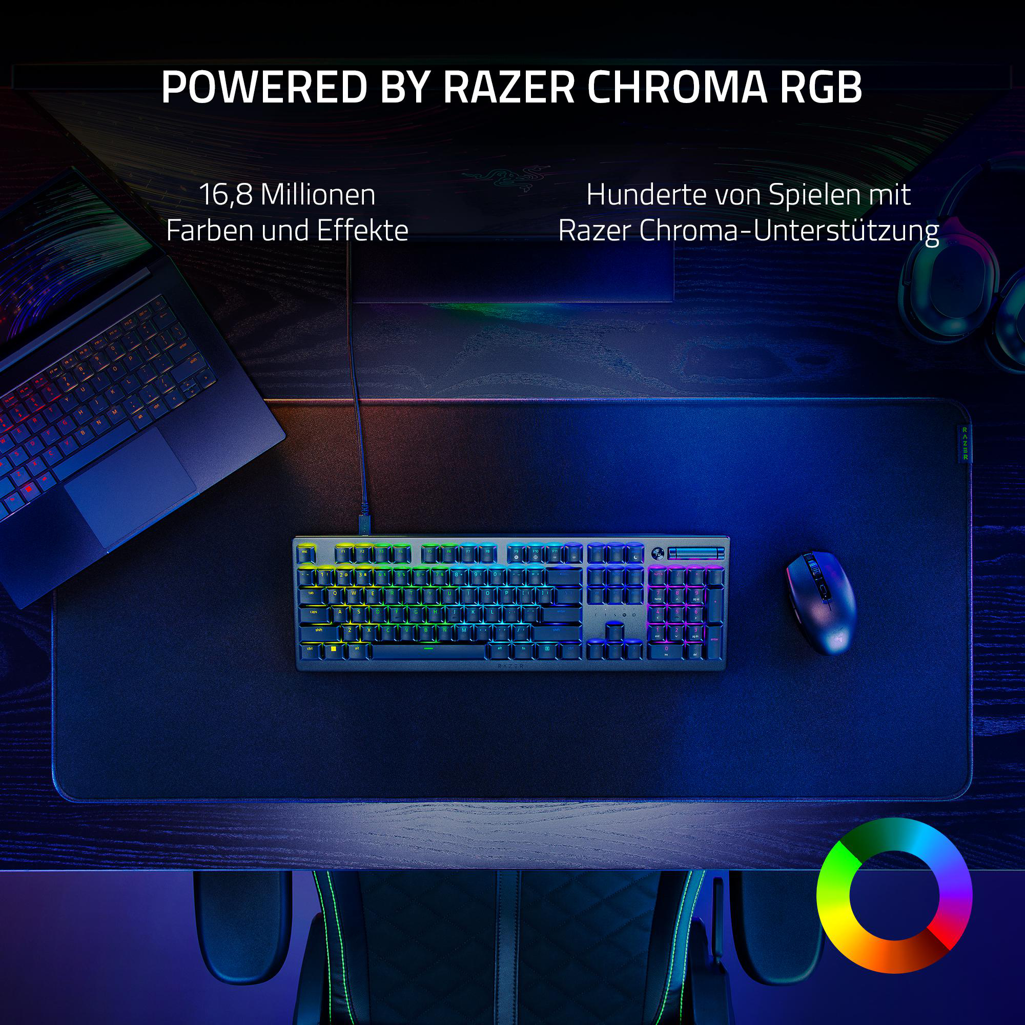 Gaming-Setup mit Tastatur, Maus und Laptop auf einem Schreibtisch, beleuchtet durch RGB-Beleuchtung.