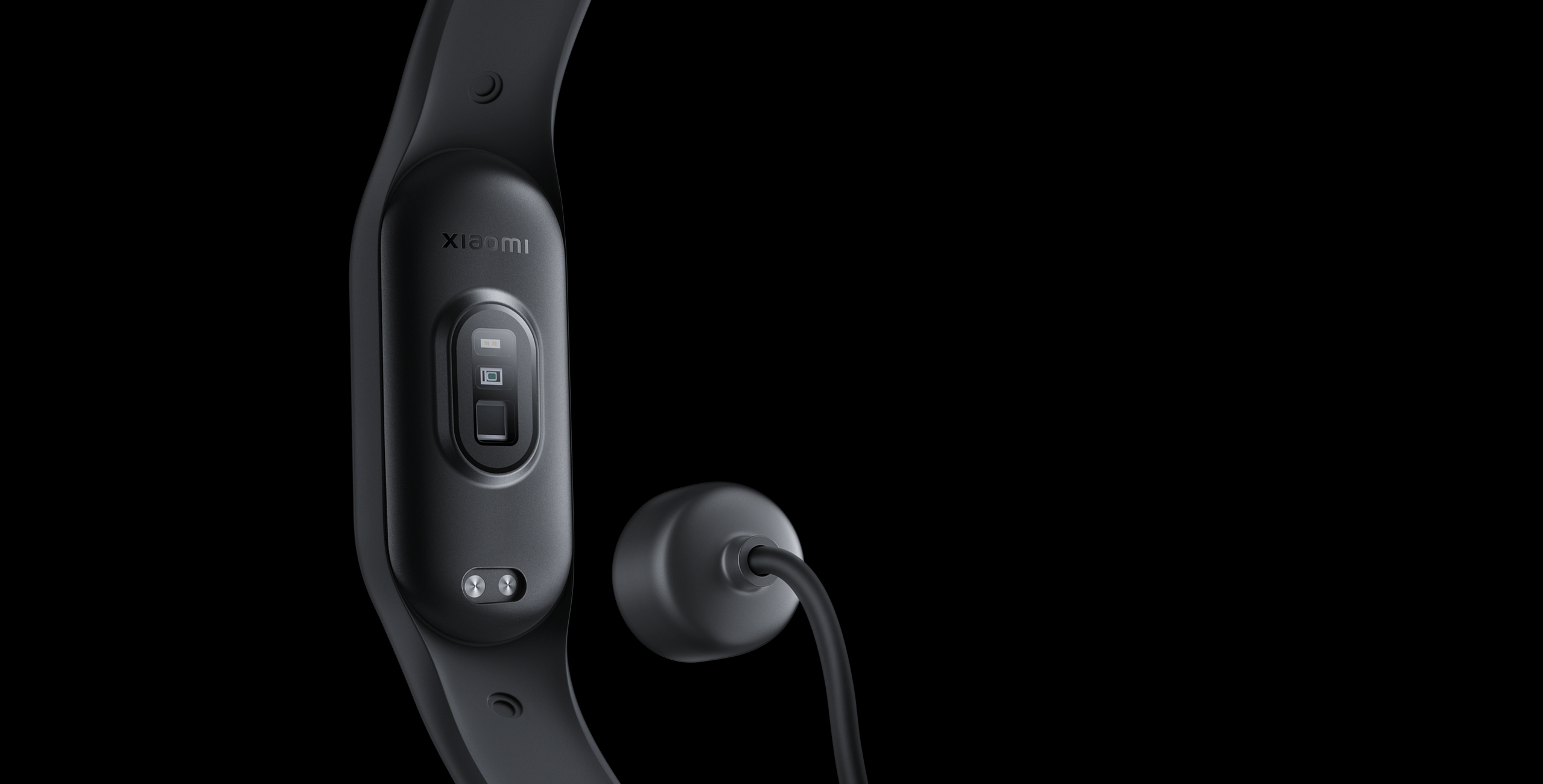 Siyah arka planda şarj cihazlı siyah Xiaomi fitness takip cihazı. Takip cihazı şarj cihazına bağlıdır.