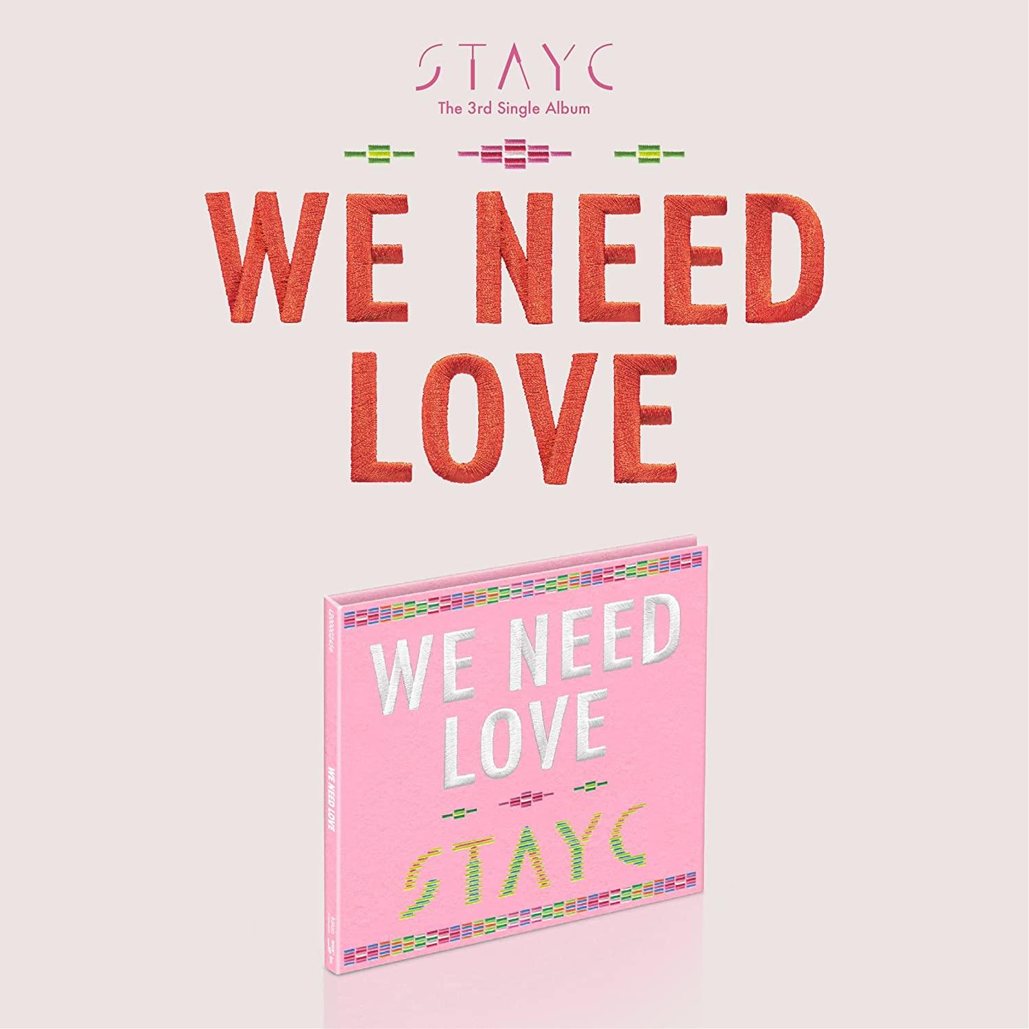 Rosa Albumcover mit rotem Text und einer CD. Der Text lautet 'WE NEED LOVE'.