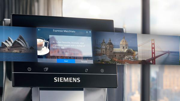 Der Bildschirm einer Kaffeemaschine zeigt verschiedene Orte, darunter Sydney und New York.