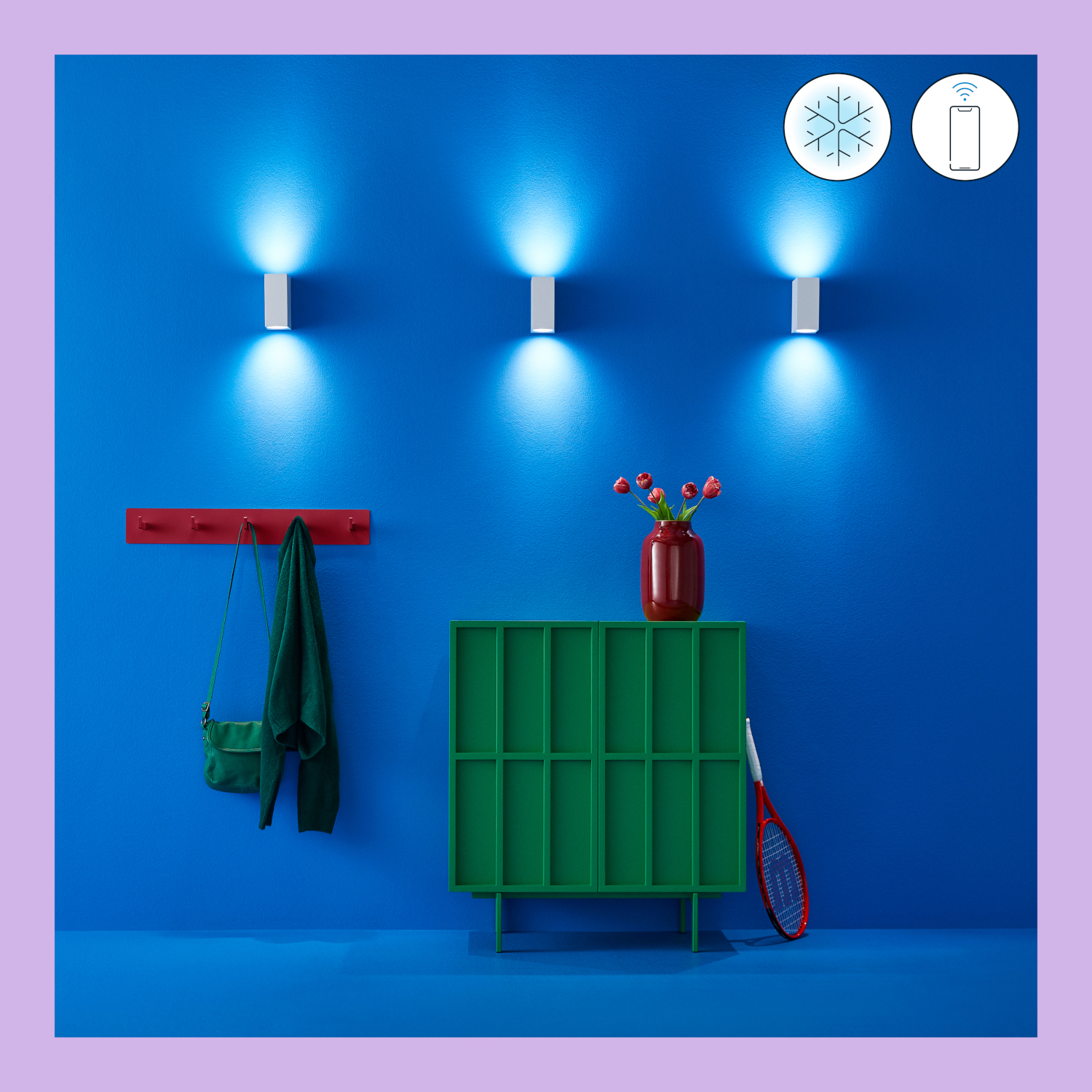 Drie witte wandlampen die blauw licht uitstralen op een blauwe muur, met een rode kapstok.
