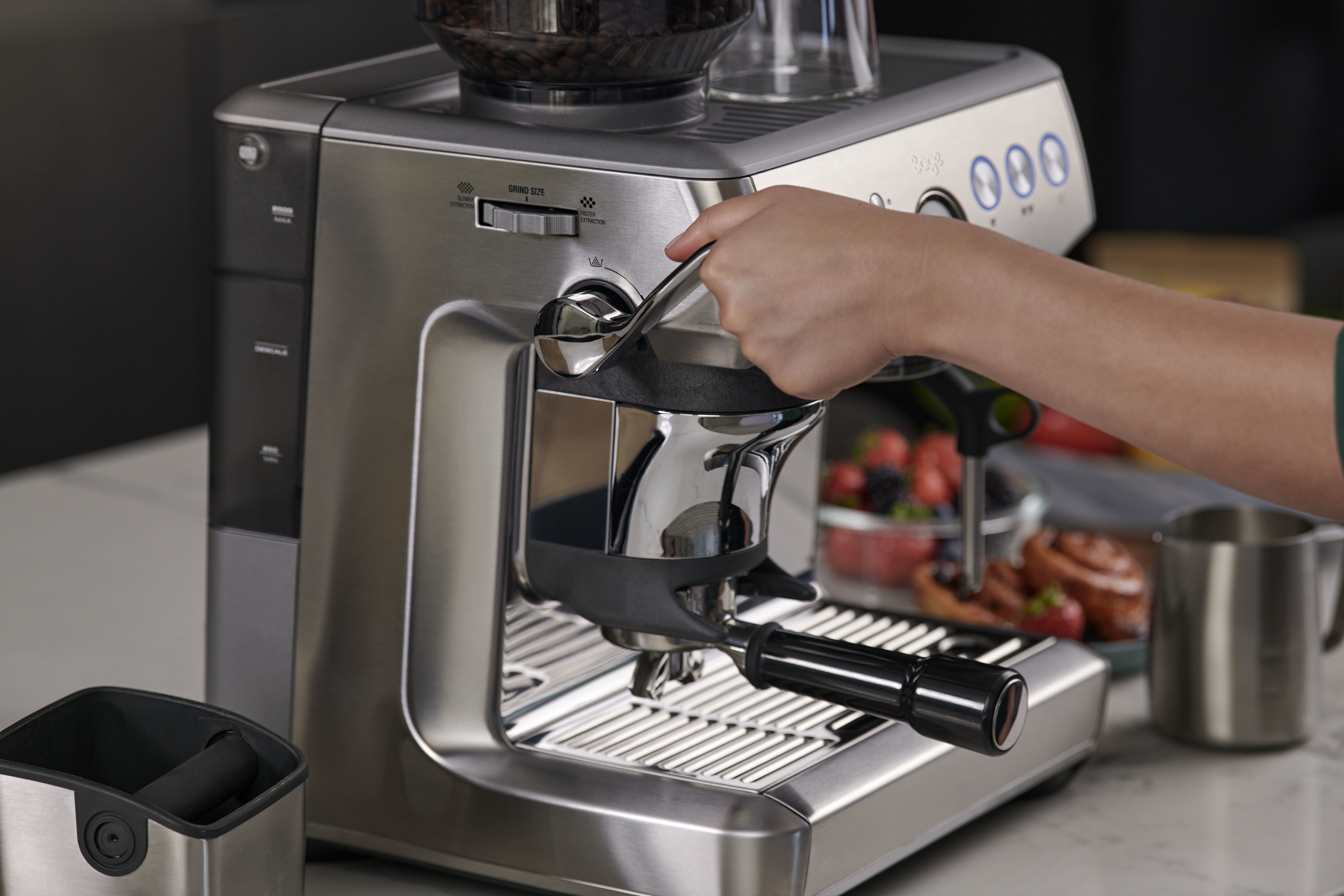 Une personne utilisant une machine à expresso argentée.