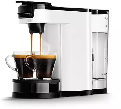 Wit en zwart koffiezetapparaat dat koffie in twee glazen kopjes schenkt.
