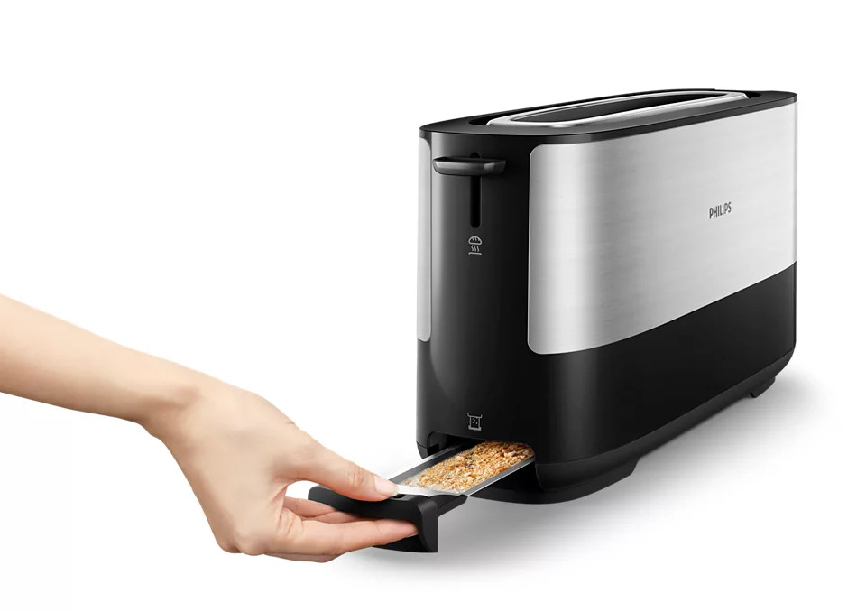 A hand is removing toast from a black and silver toaster.