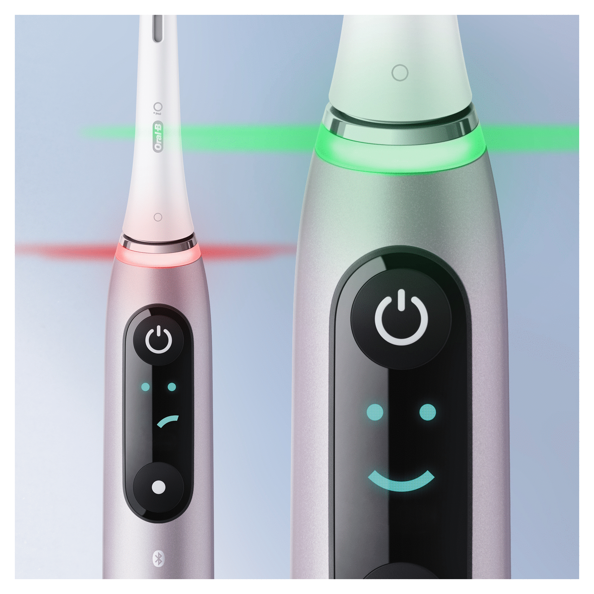 Close-up van twee elektrische tandenborstels. Eén roze, één zilver, met stroom- en glimlachindicatoren.