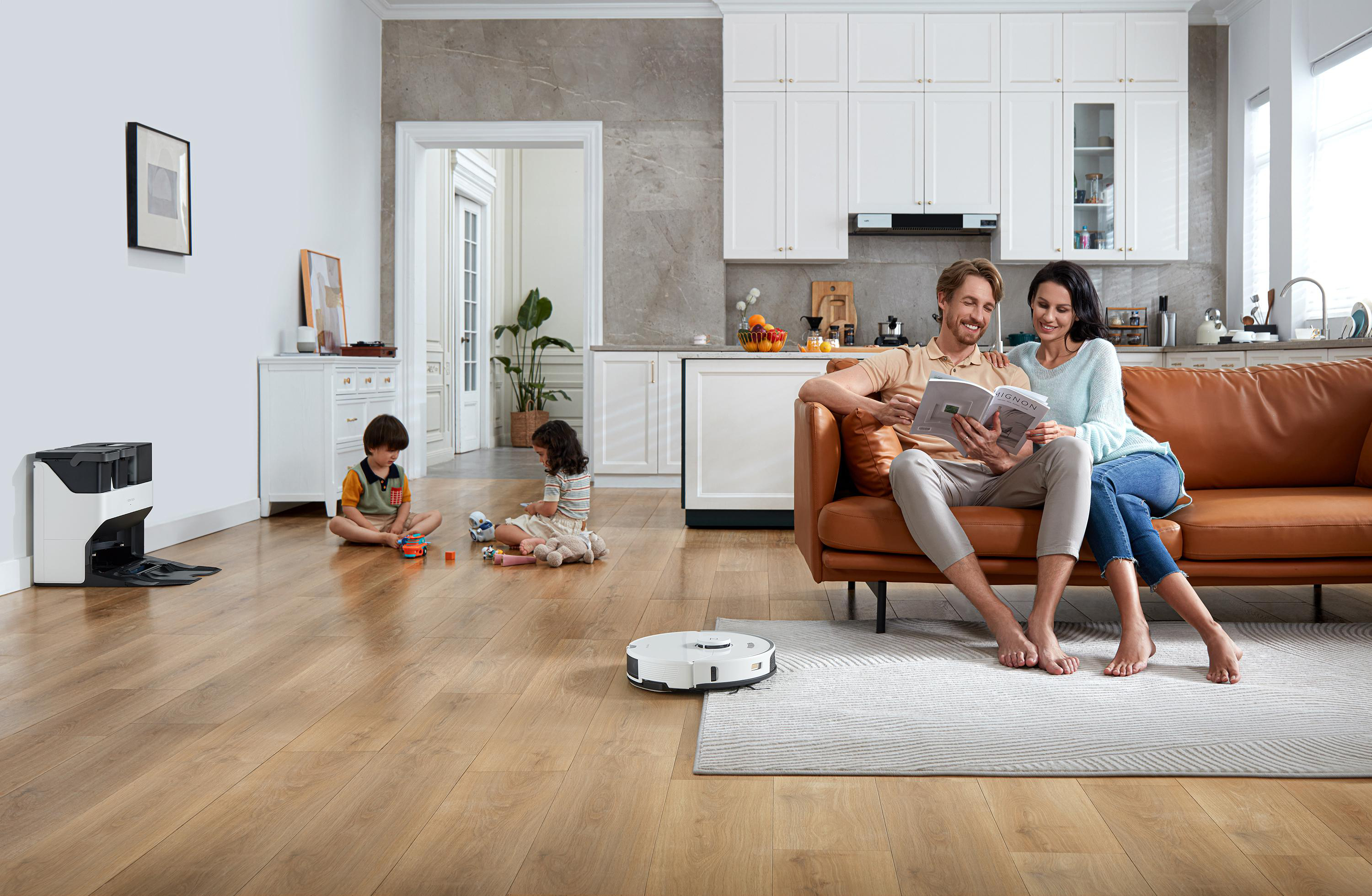 Familie in einem Wohnzimmer mit einem Roboter-Staubsauger. Helles, modernes Interieur.