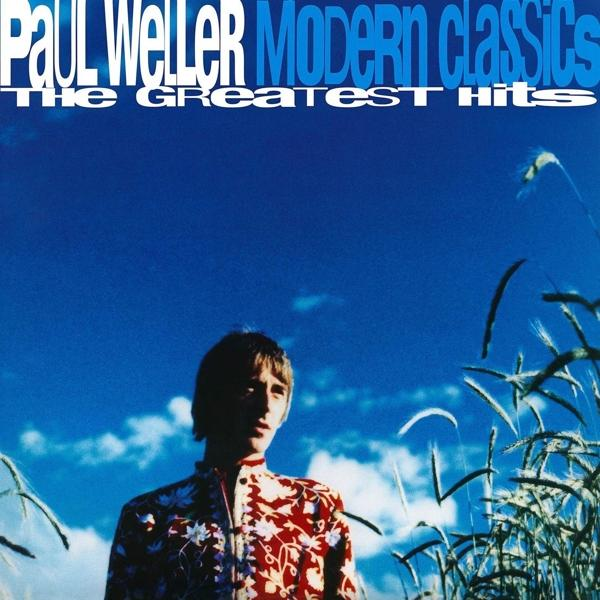Albumcover 'Paul Weller Modern Classics'. Mann mit Blumenhemd vor blauem Himmel und hohem Gras.