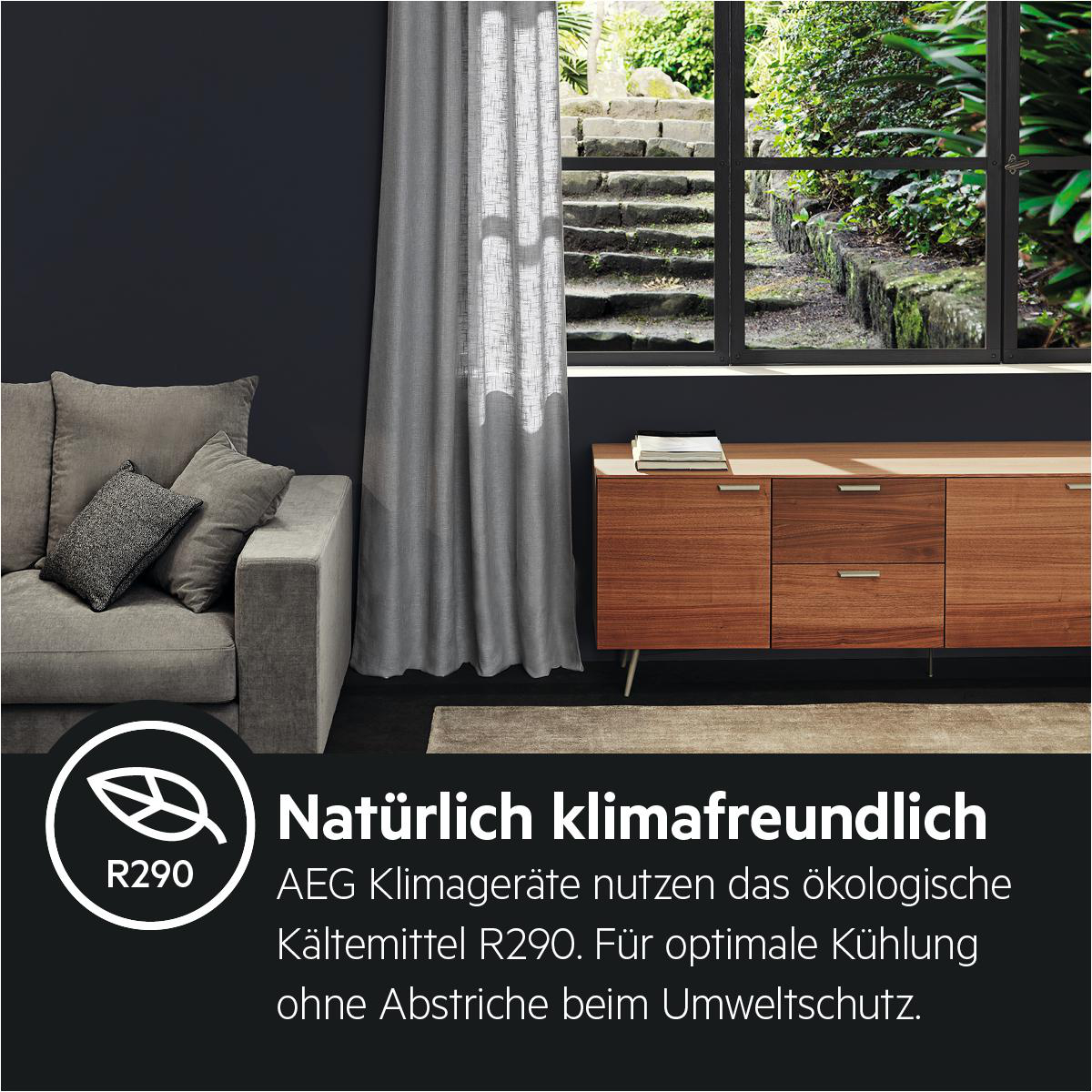Graues Sofa mit Kissen, dunkle Wand, Fenster mit Aussicht, Holzschrank.