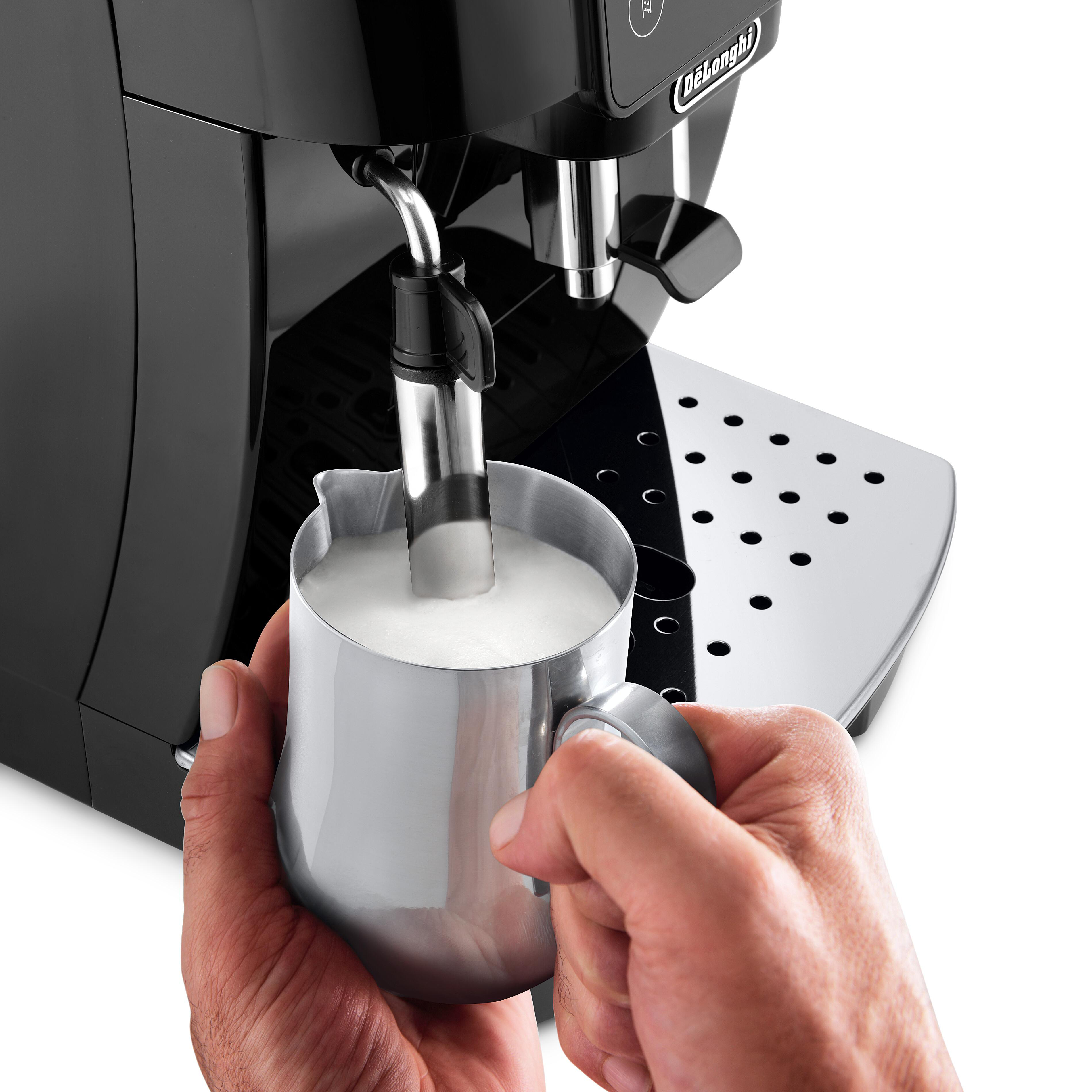 Nahaufnahme der Hände einer Person, die eine Kaffeemaschine zum Aufschäumen von Milch benutzt.