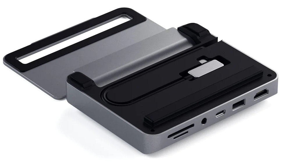 Egy ezüst és fekete USB-C hub több porttal és fedéllel. A fedél nyitva van, fekete belsőt mutat kábellel.