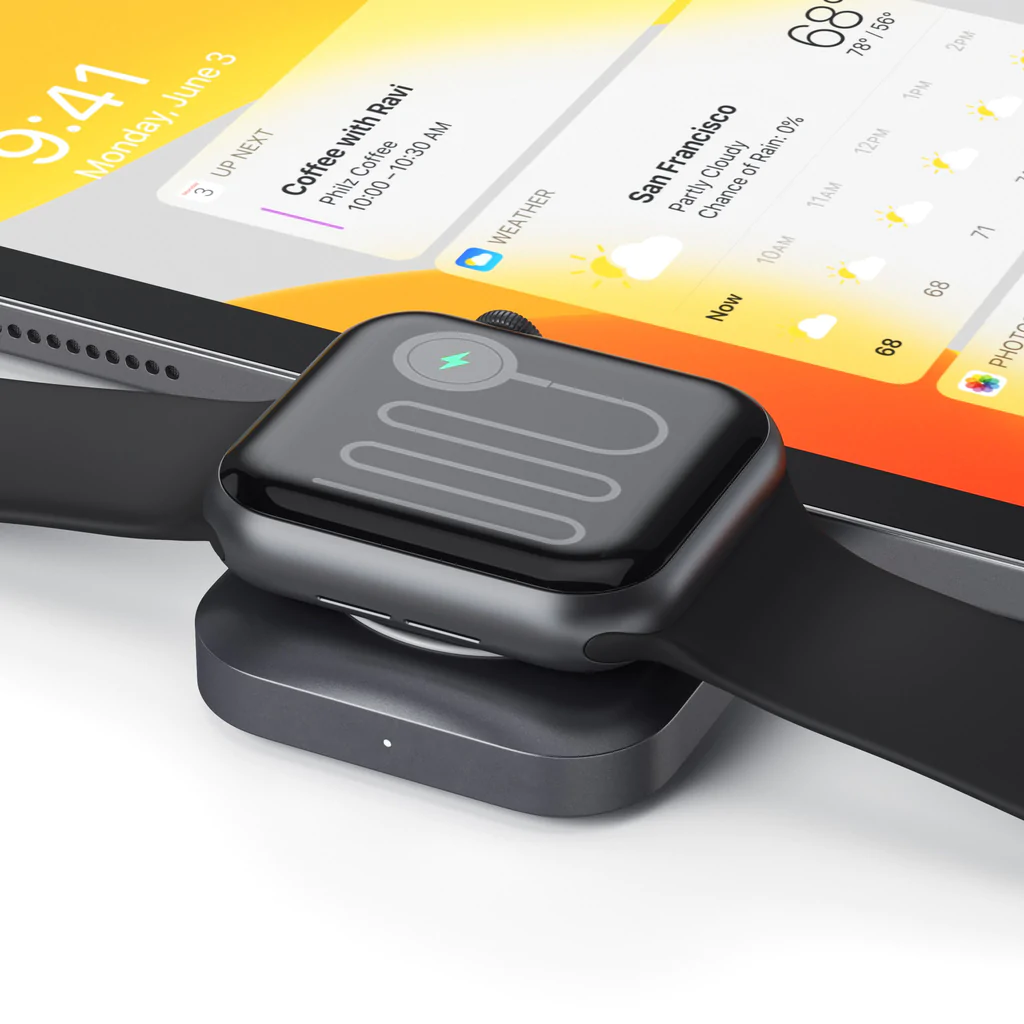Egy vezeték nélküli töltő Apple Watch-csal, mögötte egy tablettel.