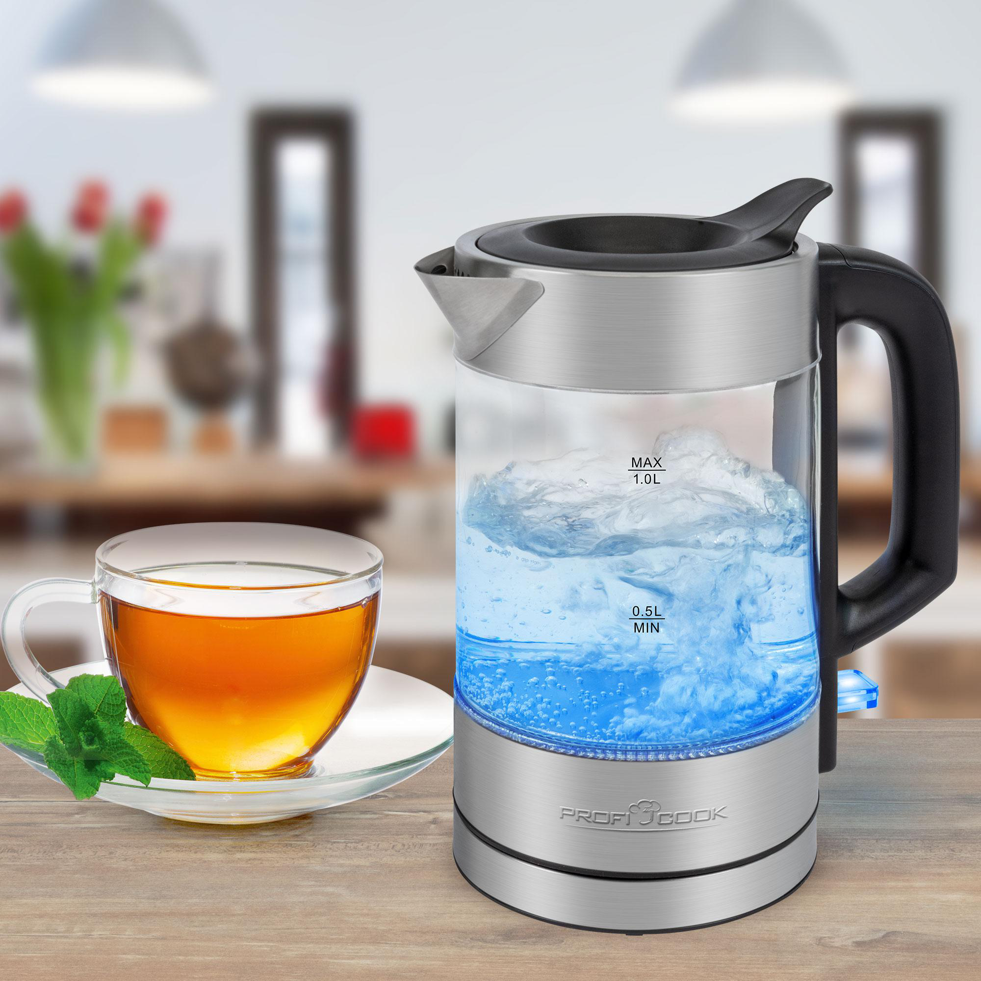 Elektrischer Glaskessel, kochendes Wasser, Tasse Tee, Holztisch.