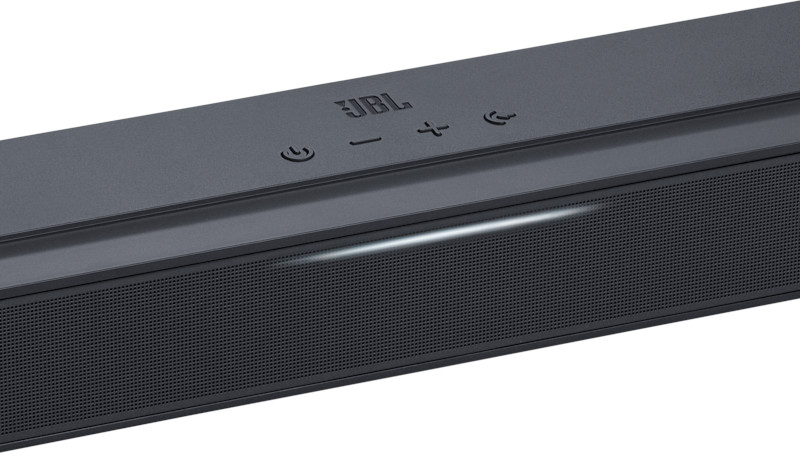 Barre de son JBL noire, gros plan, avec boutons et lumière.