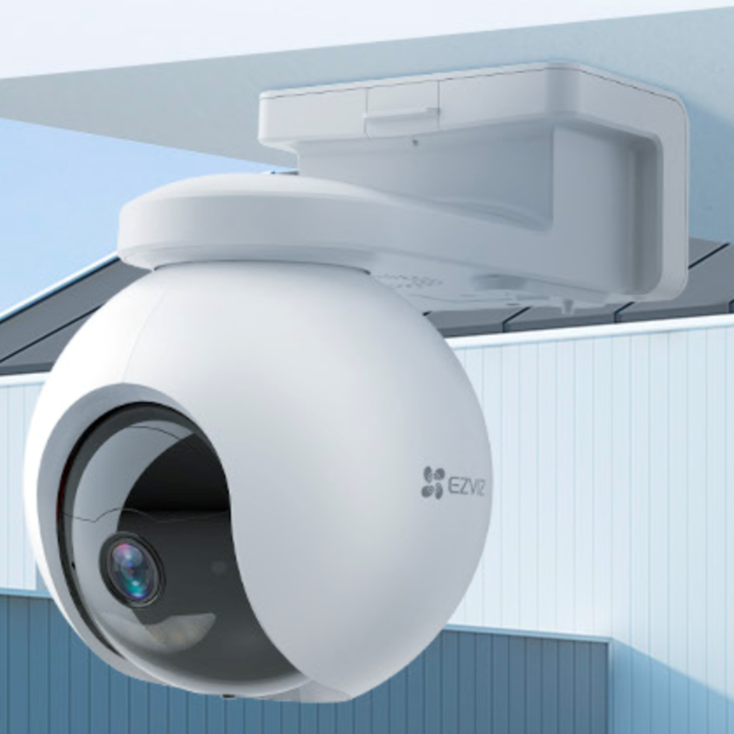 White security camera mounted on a wall. The background is blurry.