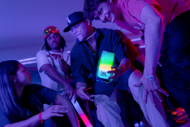 Vier Leute, darunter einer, der einen Farbwechsel-Lautsprecher hält.