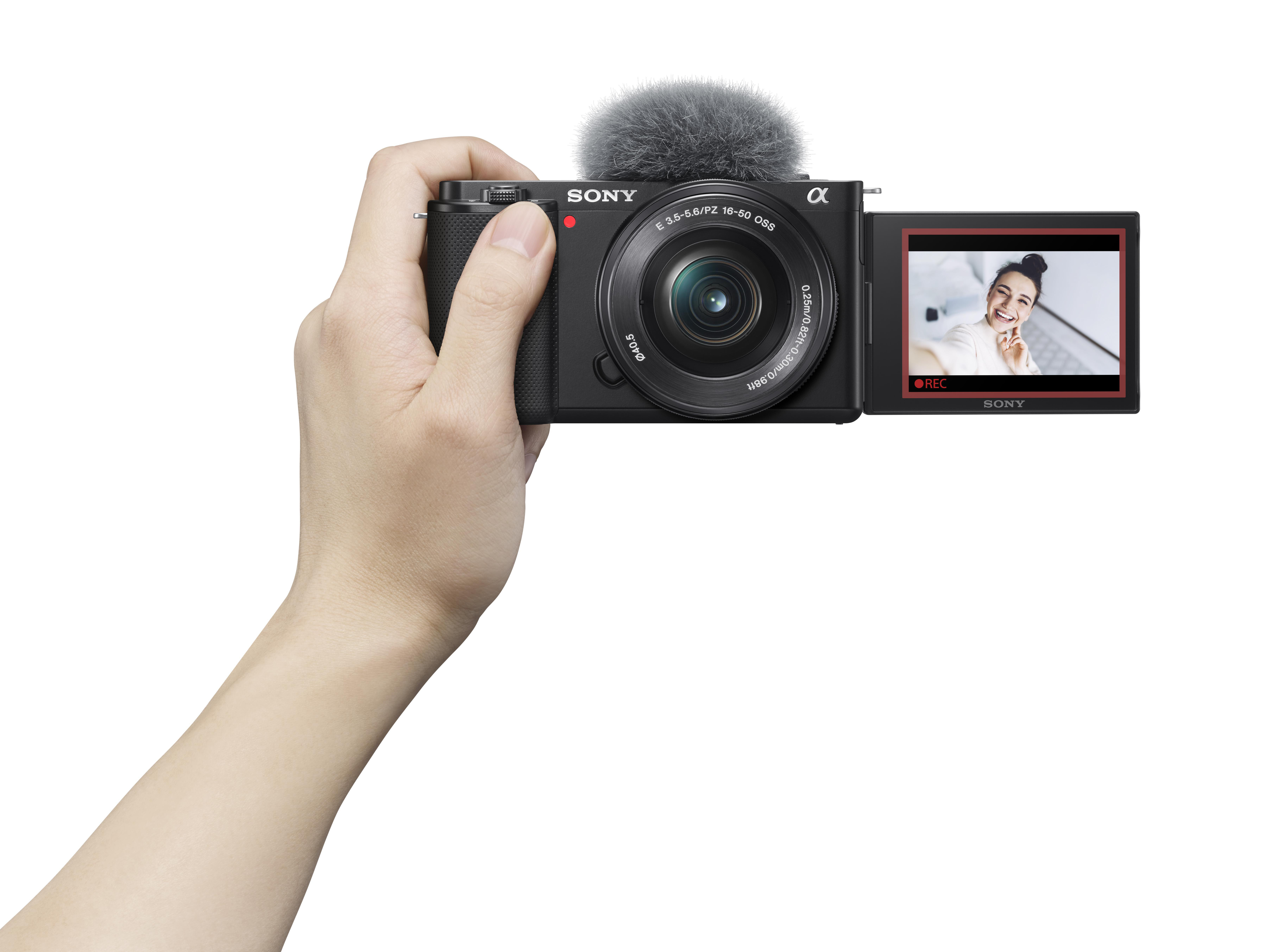Eine Hand, die eine schwarze Sony-Kamera hält und einen Live-Bildschirm einer Frau zeigt.