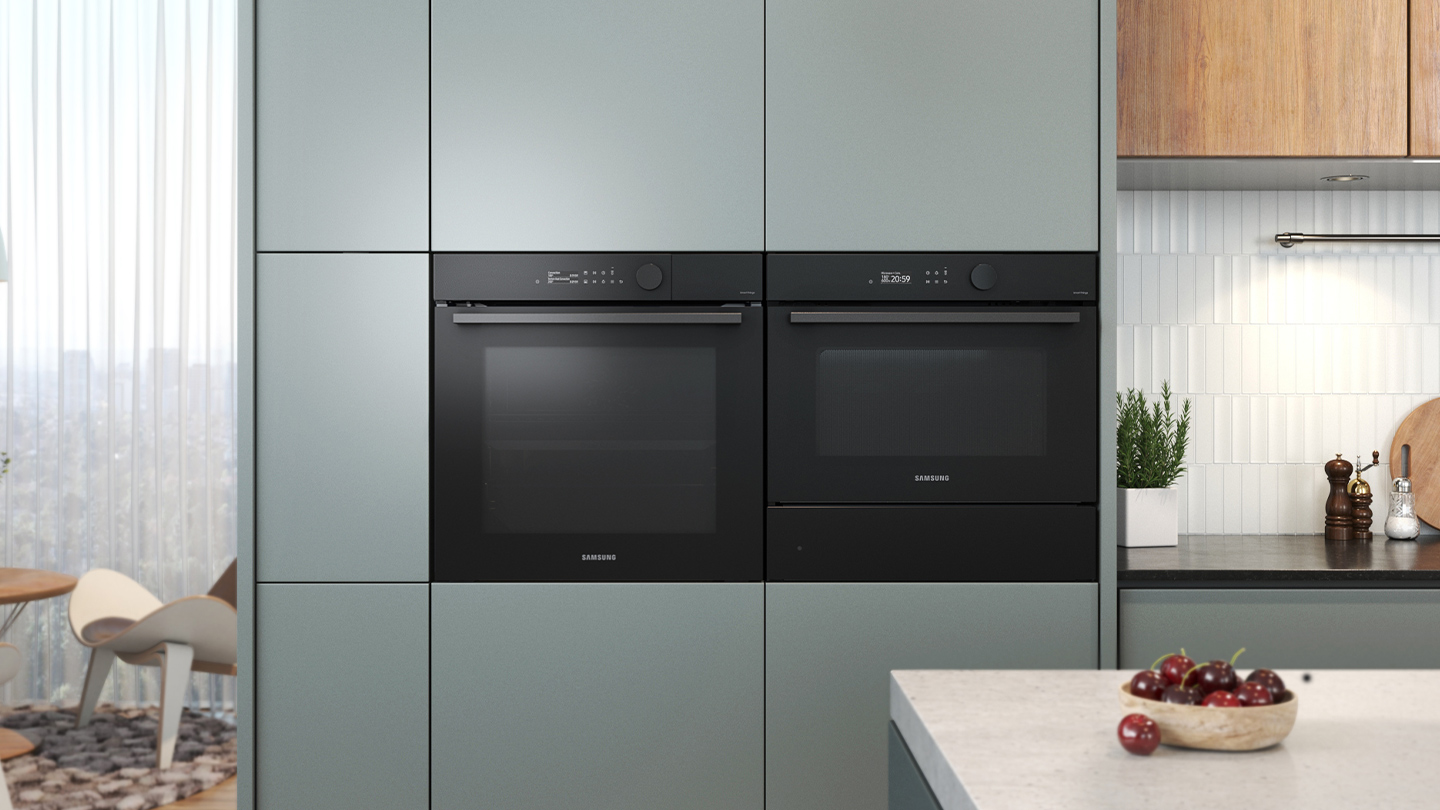 Ingebouwde ovens in een keuken, zwarte apparaten, lichtgroene kasten, kersenschaal.