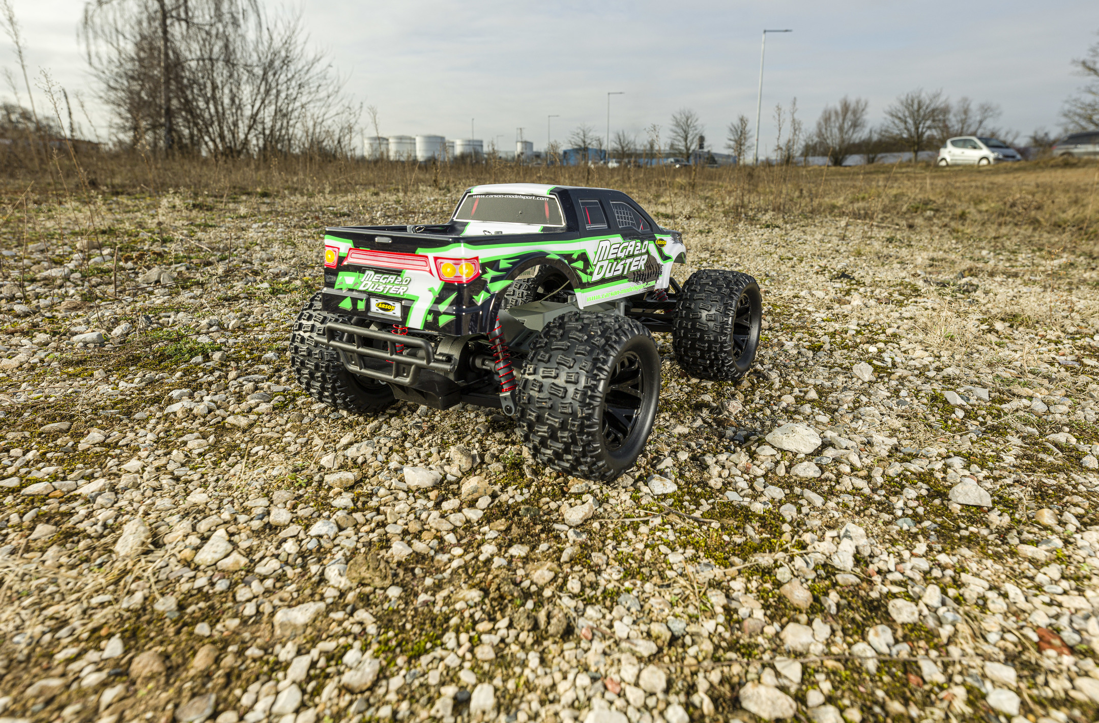 Ferngesteuerter Monstertruck. Schwarze, grüne und weiße Karosserie auf Kies.