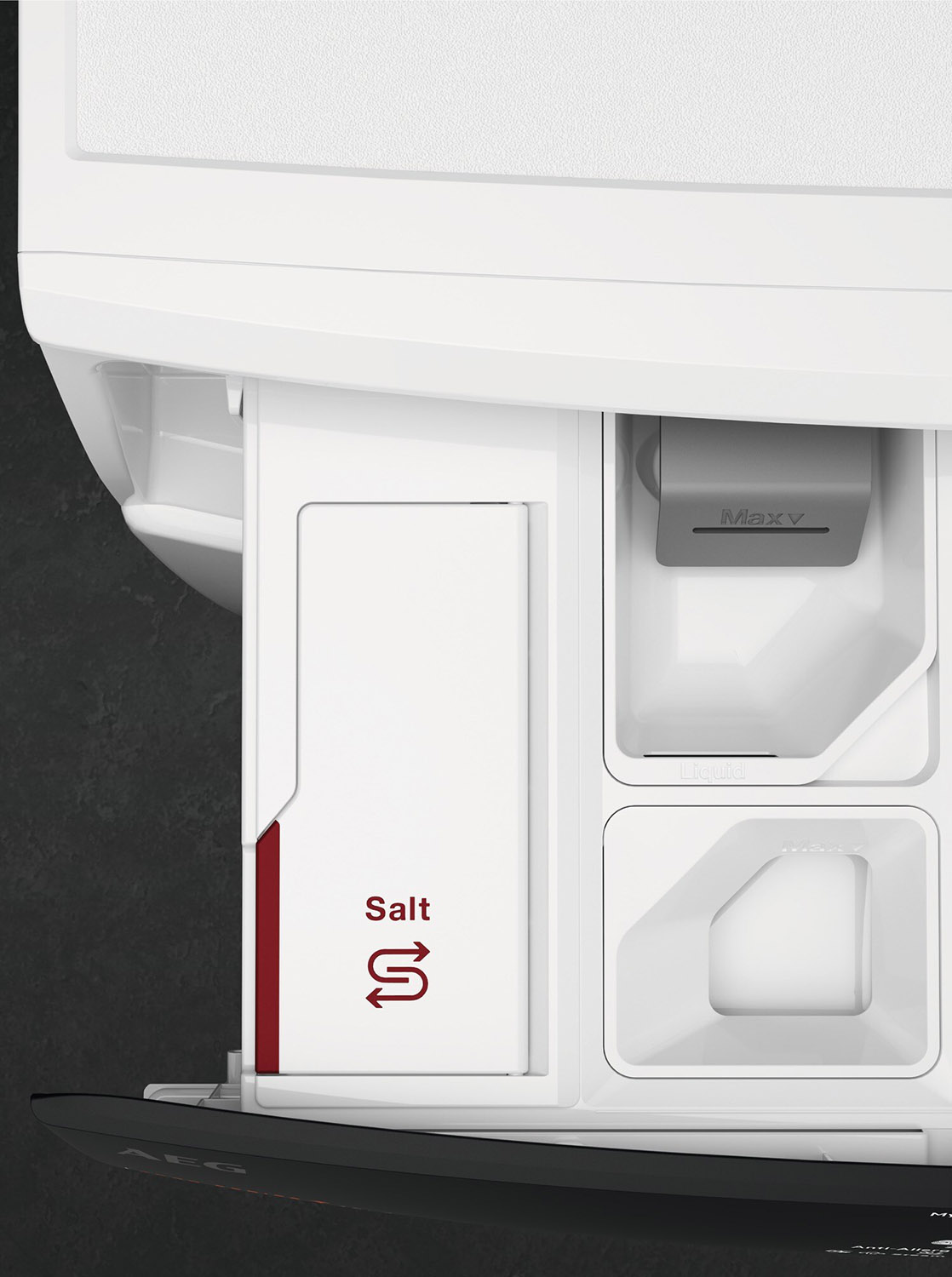 Close-up of a white washing machine drawer with compartments labeled. One is marked 'Salt'.