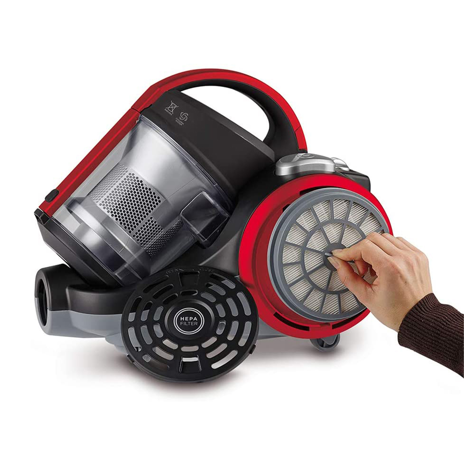 Un aspirapolvere rosso e nero. Una mano sta rimuovendo un filtro dal lato.