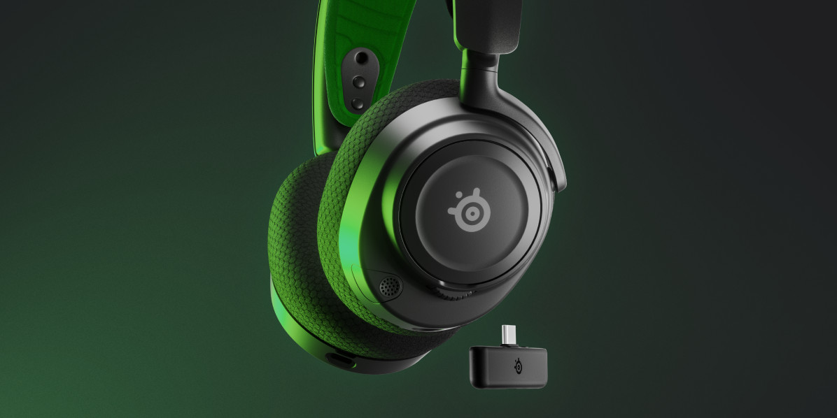 Casque de jeu noir et vert avec un petit récepteur sans fil. Fond vert.