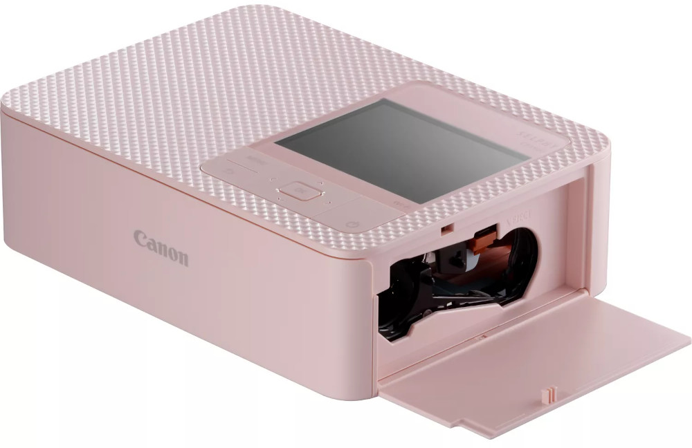 Pink Canon Selphy photo printer. Open to reveal the paper and battery compartment, showing its internal parts.