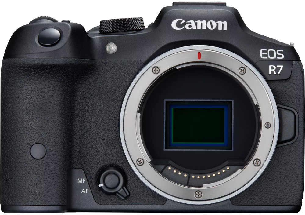Een zwarte Canon EOS R7 camera met lensvatting en knoppen. Het Canon logo is zichtbaar.
