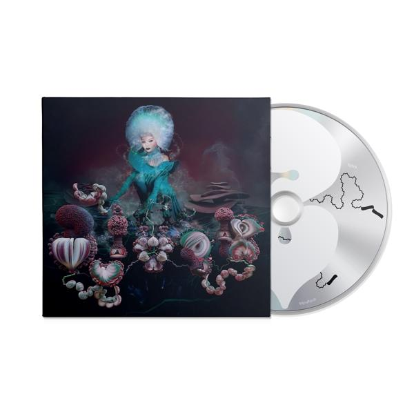 Albumcover mit einer Frau in blauem Kleid, umgeben von surrealen, farbenfrohen Objekten.