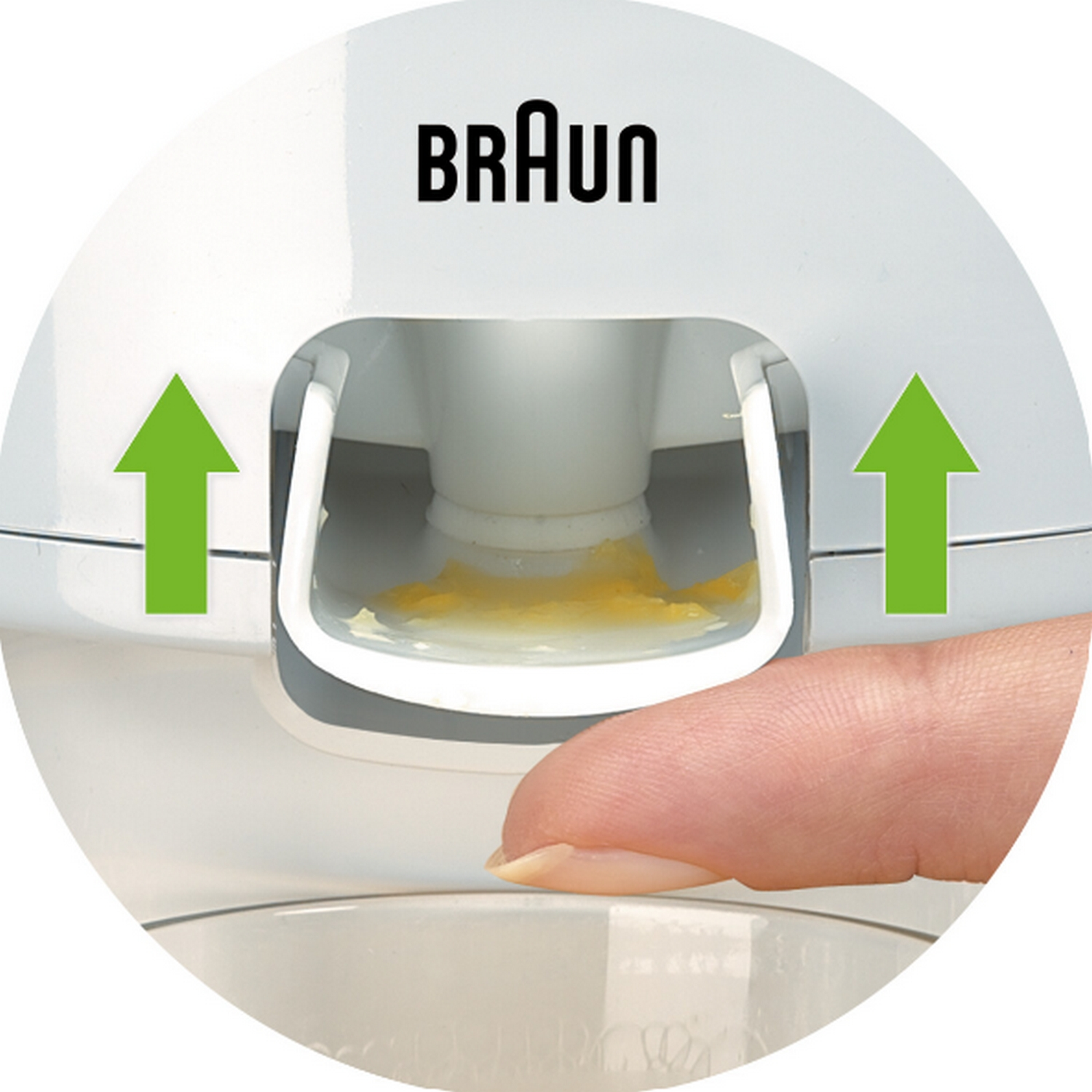 Primer plano de un producto Braun. Un dedo presiona un botón con flechas verdes.