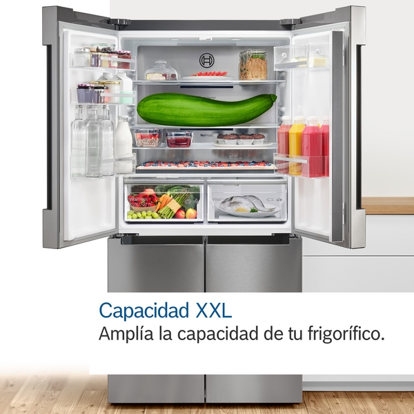 Refrigerador abierto. Contiene calabacín, frutas y verduras. Interior blanco, puertas plateadas.