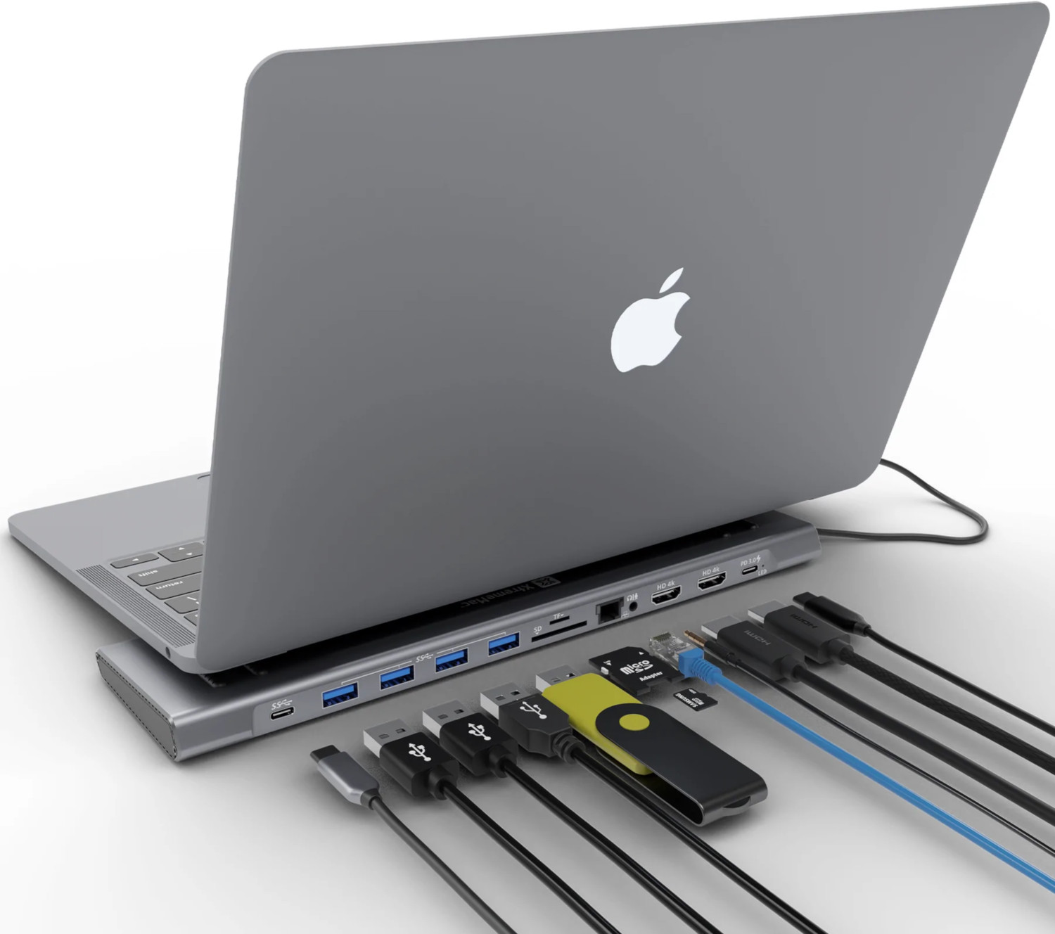 Ordinateur portable avec un hub et des câbles connectés sur une surface blanche.