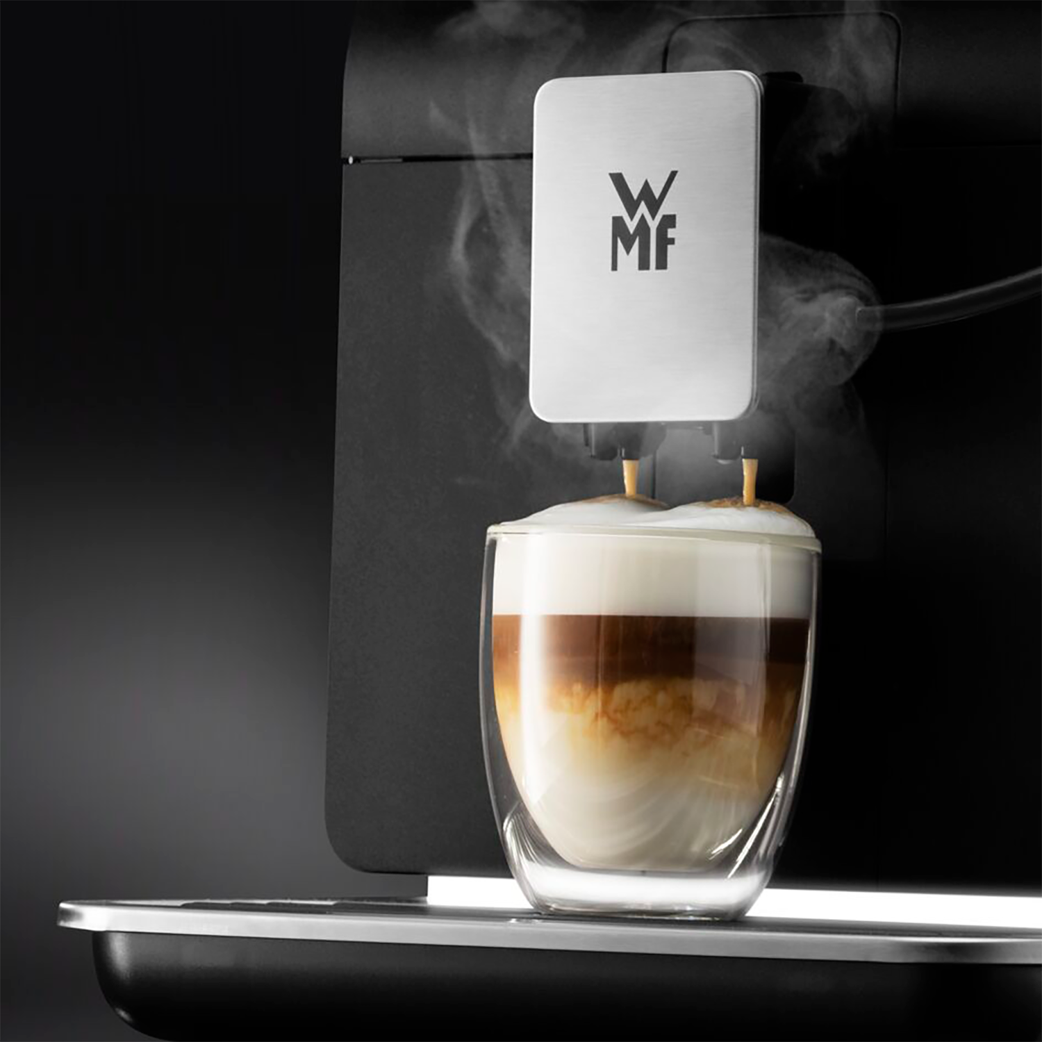 Koffiemachine die latte macchiato in een glas schenkt. Schuim en gelaagde koffie.