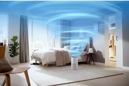 Een slaapkamer met een luchtreiniger. De reiniger is wit. De lucht stroomt in een golfpatroon.